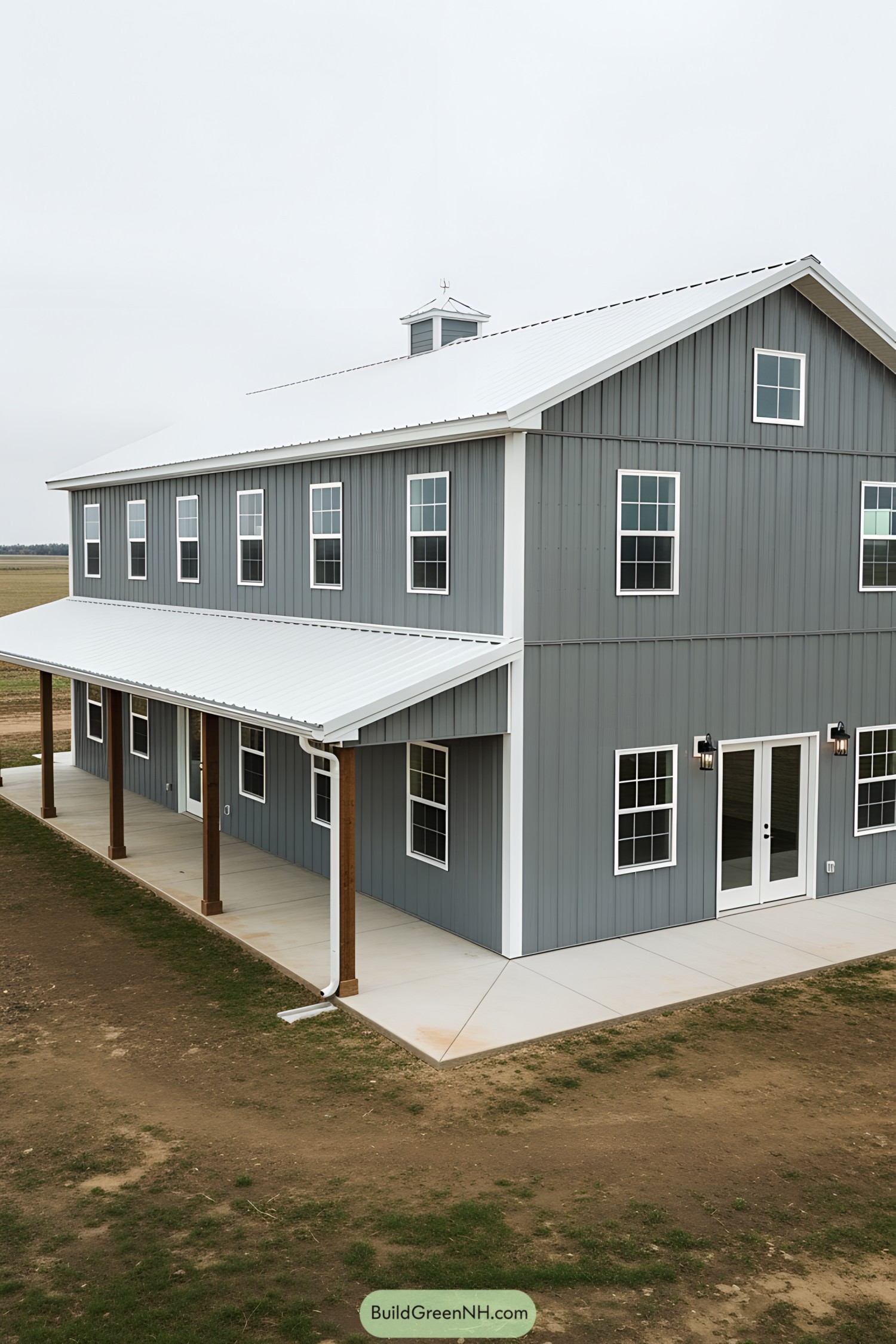 Gray barndominium with a white roof and wooden columns