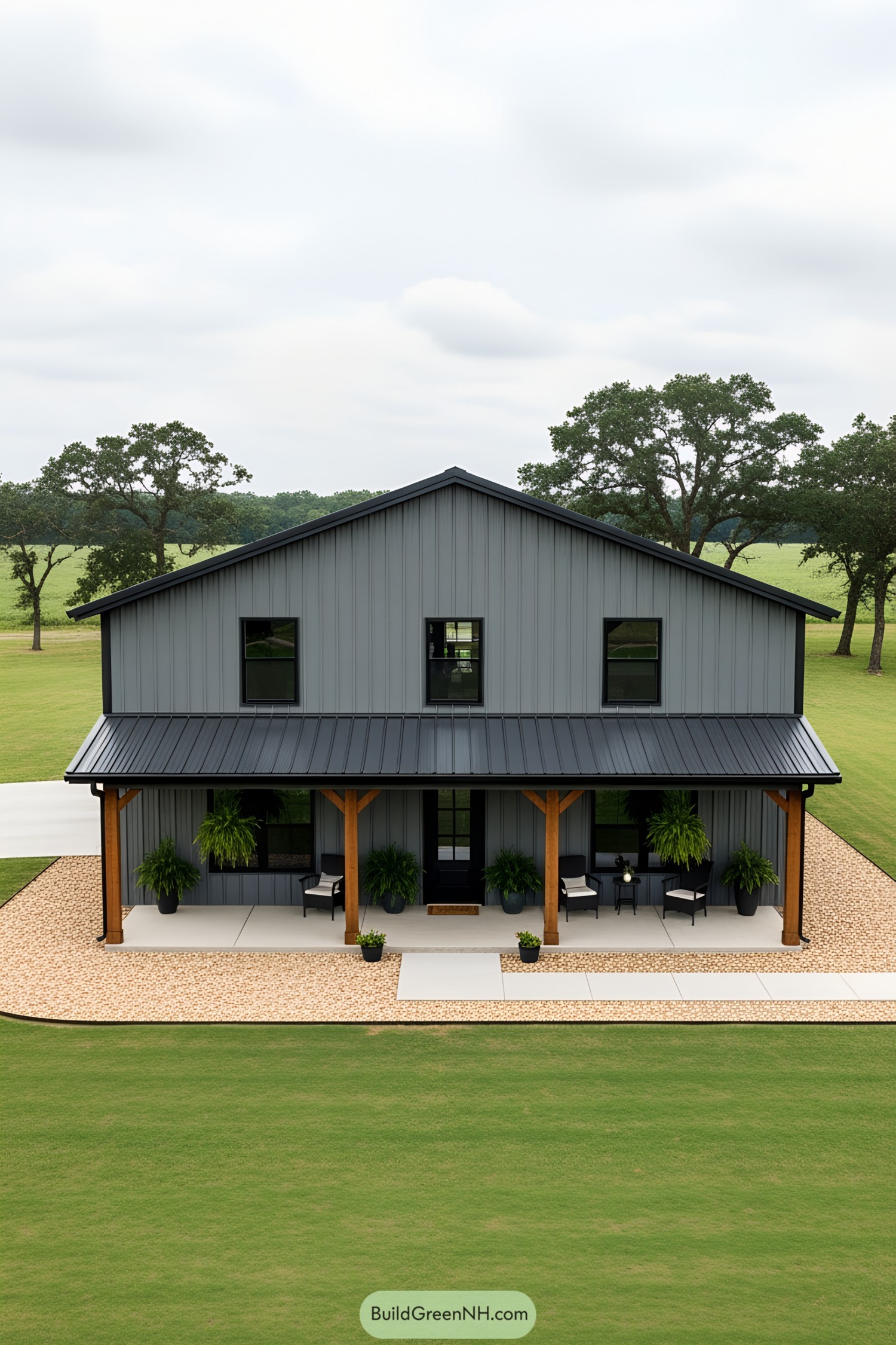 Gray barndominium with a porch and greenery