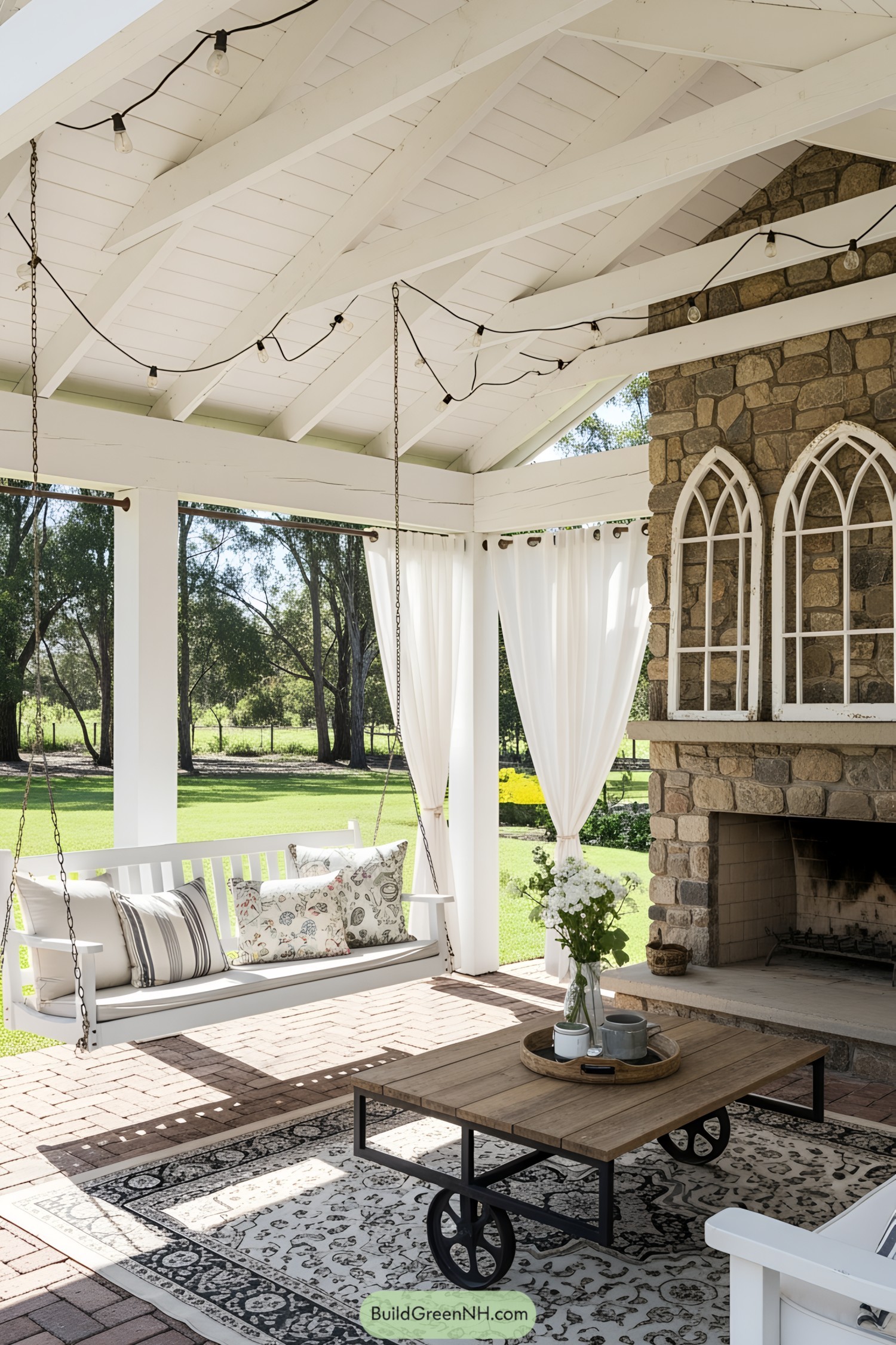 Outdoor space with swing, fireplace, and white curtains