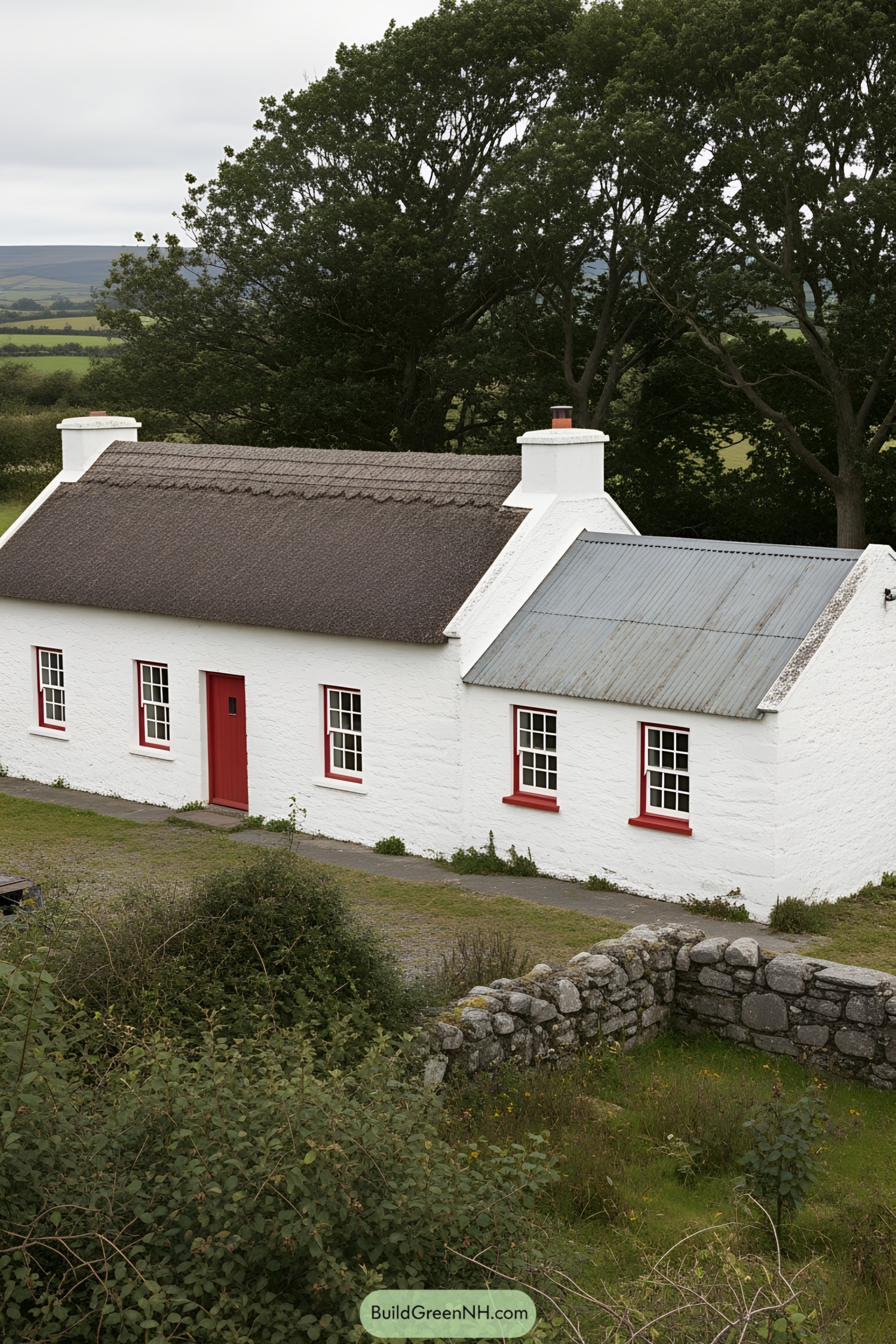 White farmhouse with red accents nestled in greenery