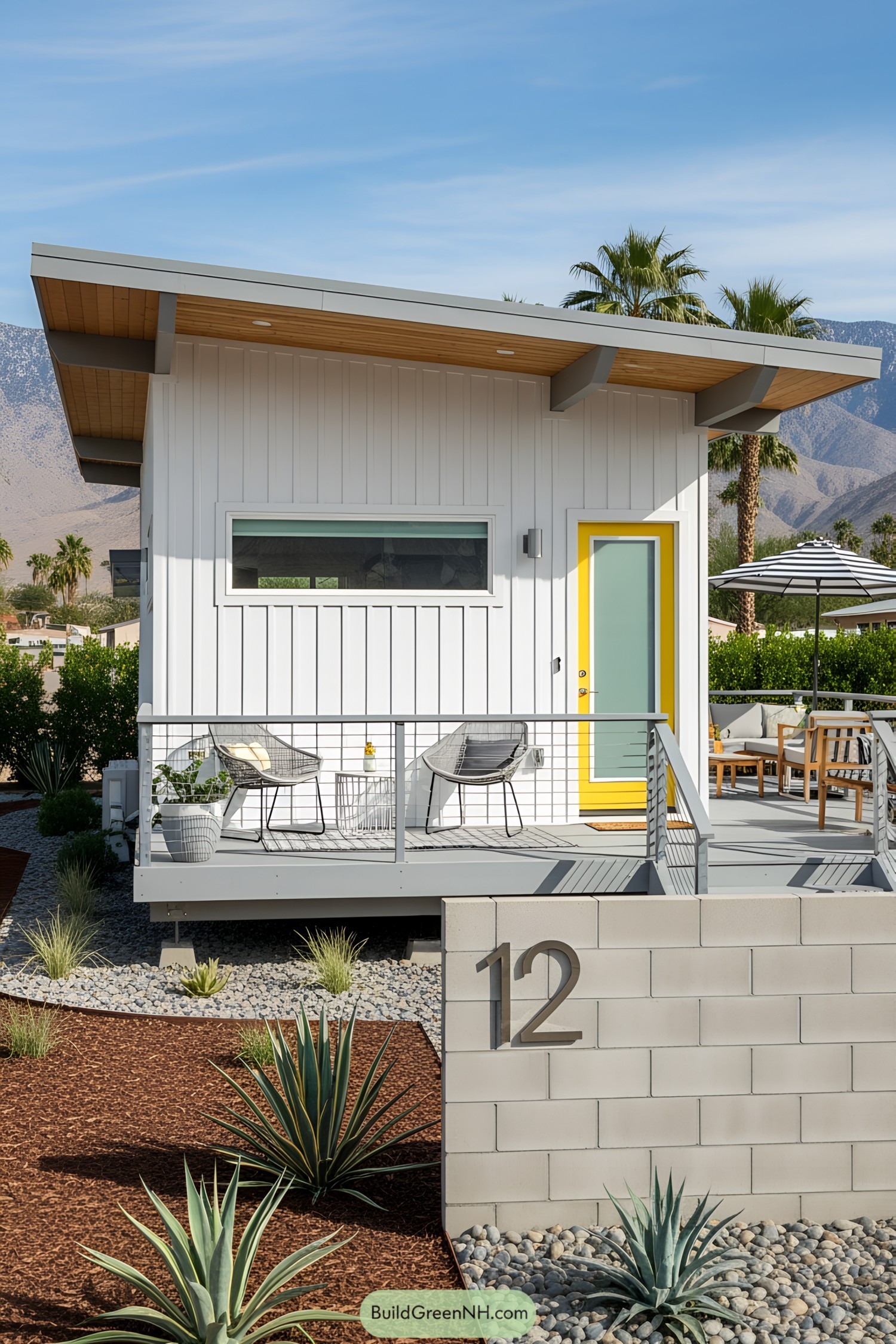 White tiny house with yellow door and cozy patio