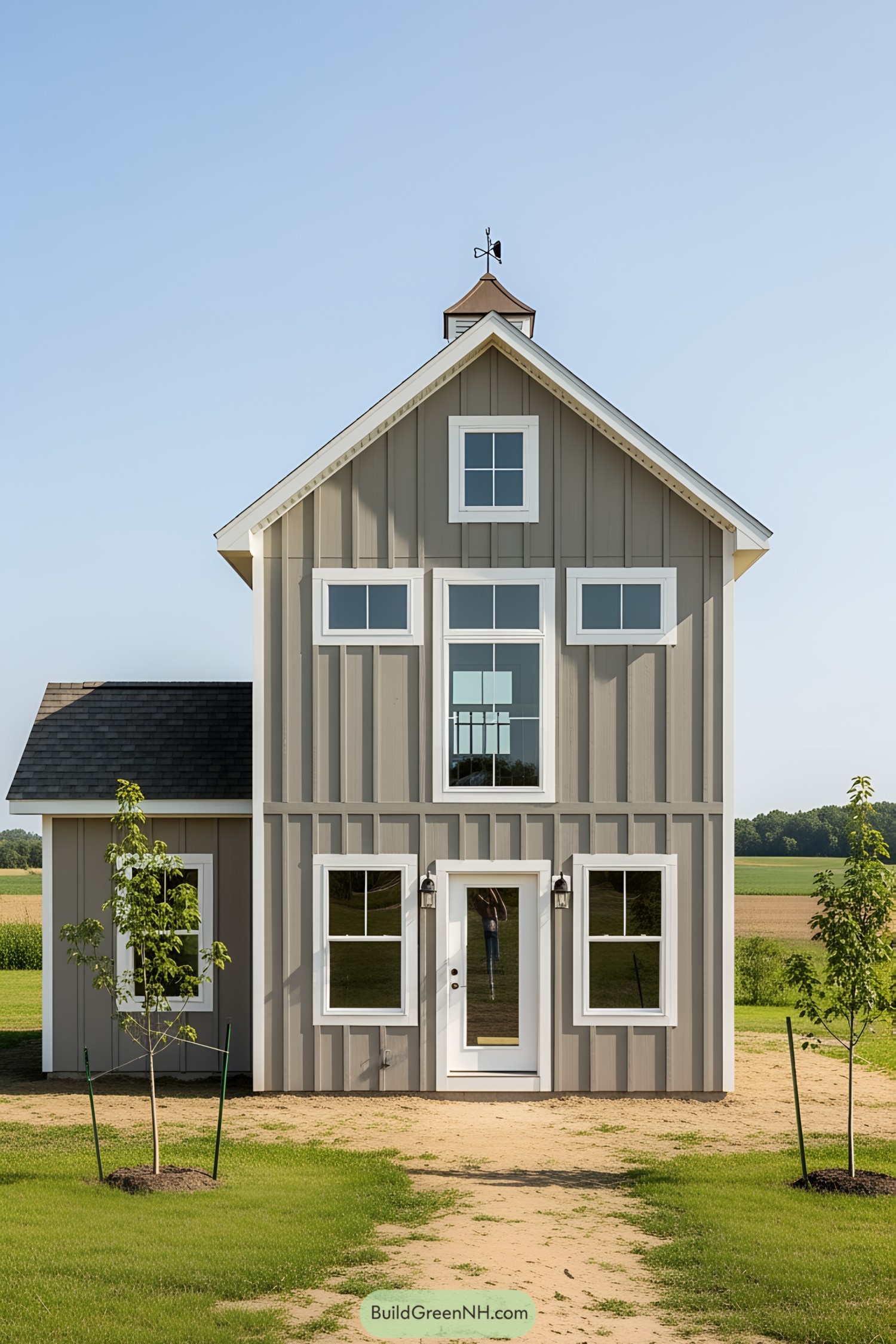 Cute gray and white mini barn house with a charming weathervane