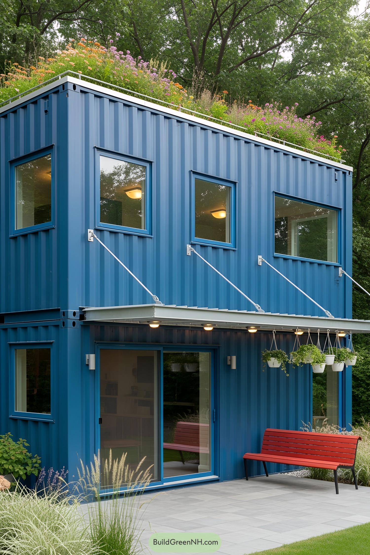 Stylish blue steel container home with a green roof garden