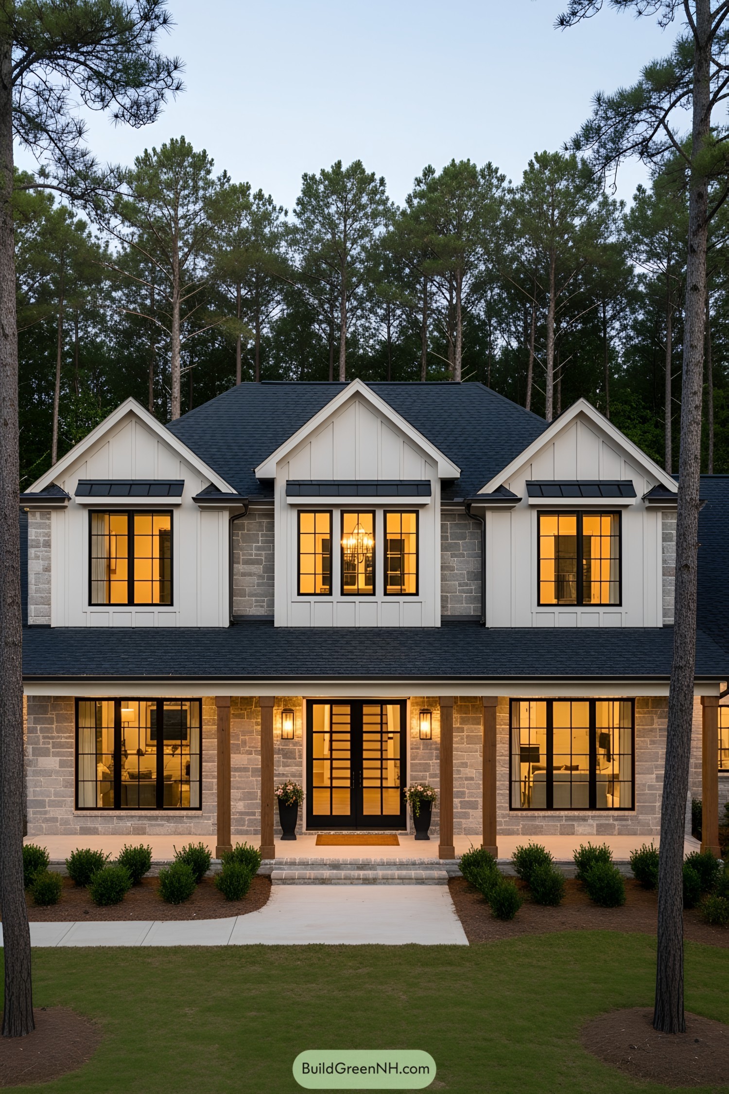 Elegant two-story country house with large windows and porch lights