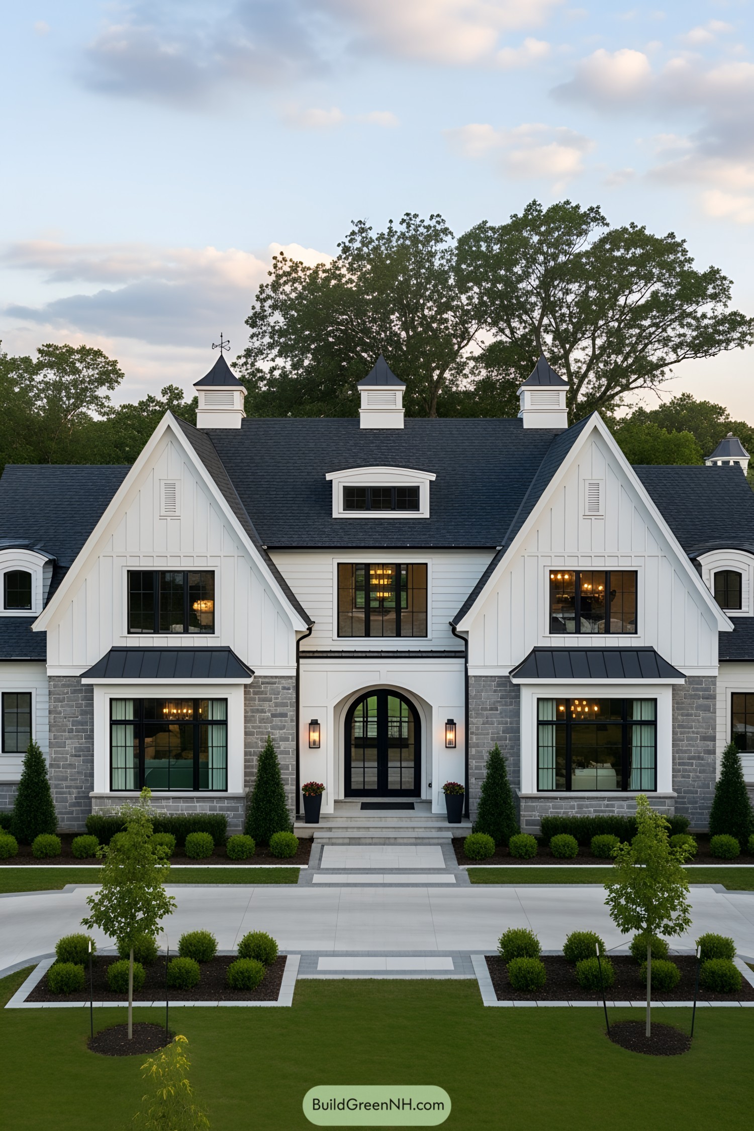 Front view of a modern country house with gable roofs and stone accents