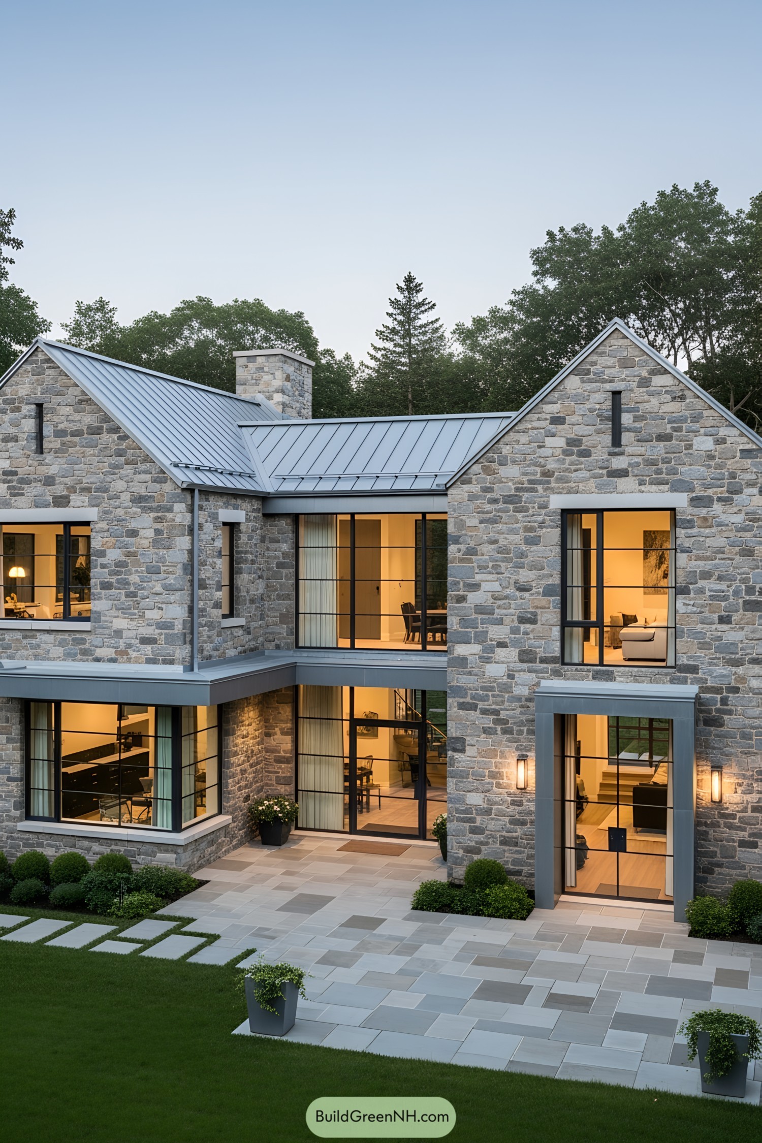 Modern stone house with large windows and a lush lawn