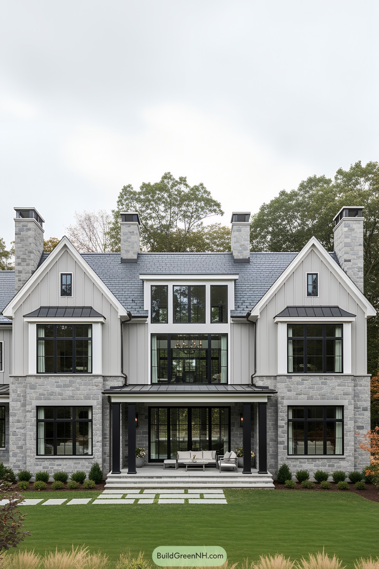 Modern stone house with large windows and lush lawn