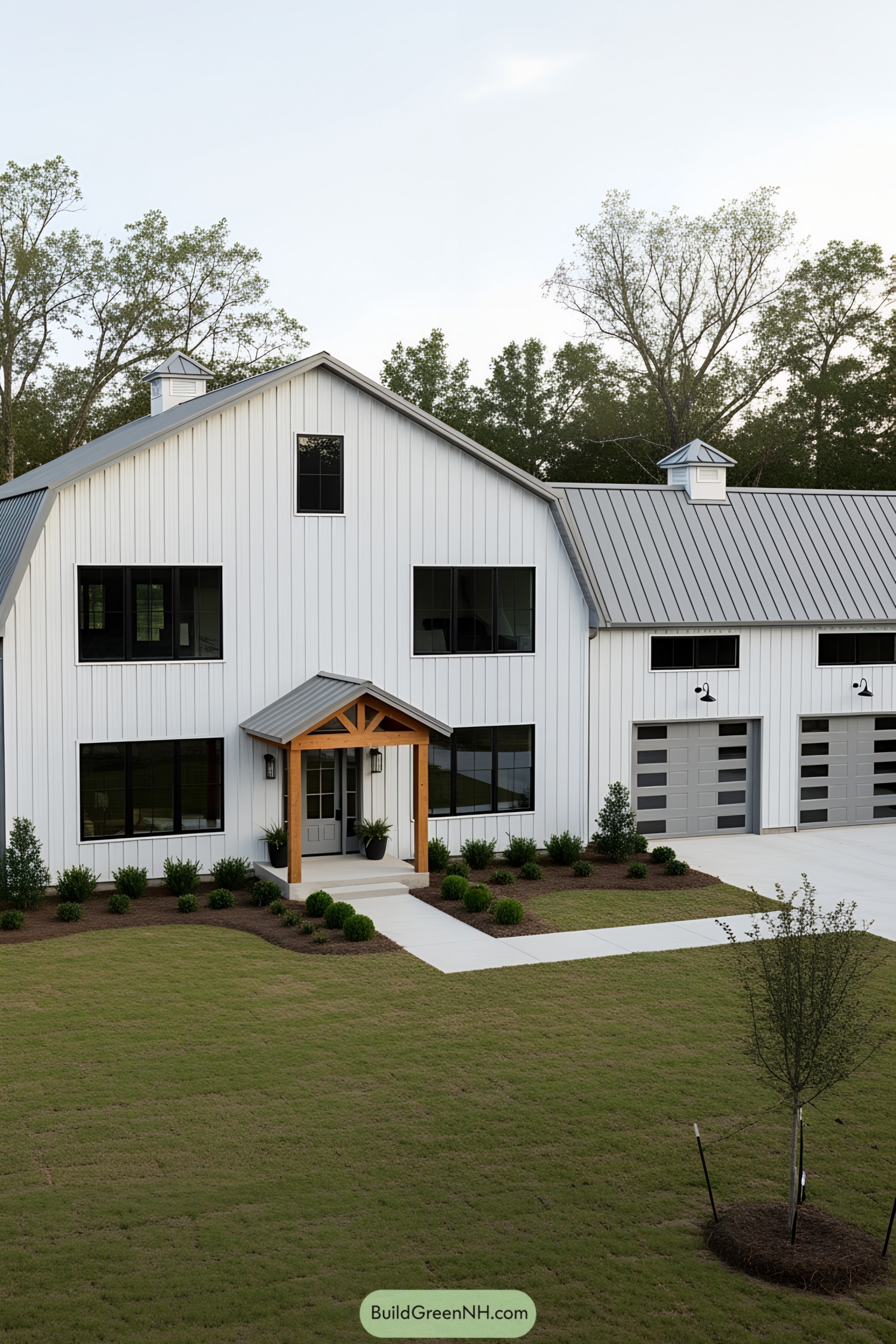 White barndominium with large windows and a metal roof