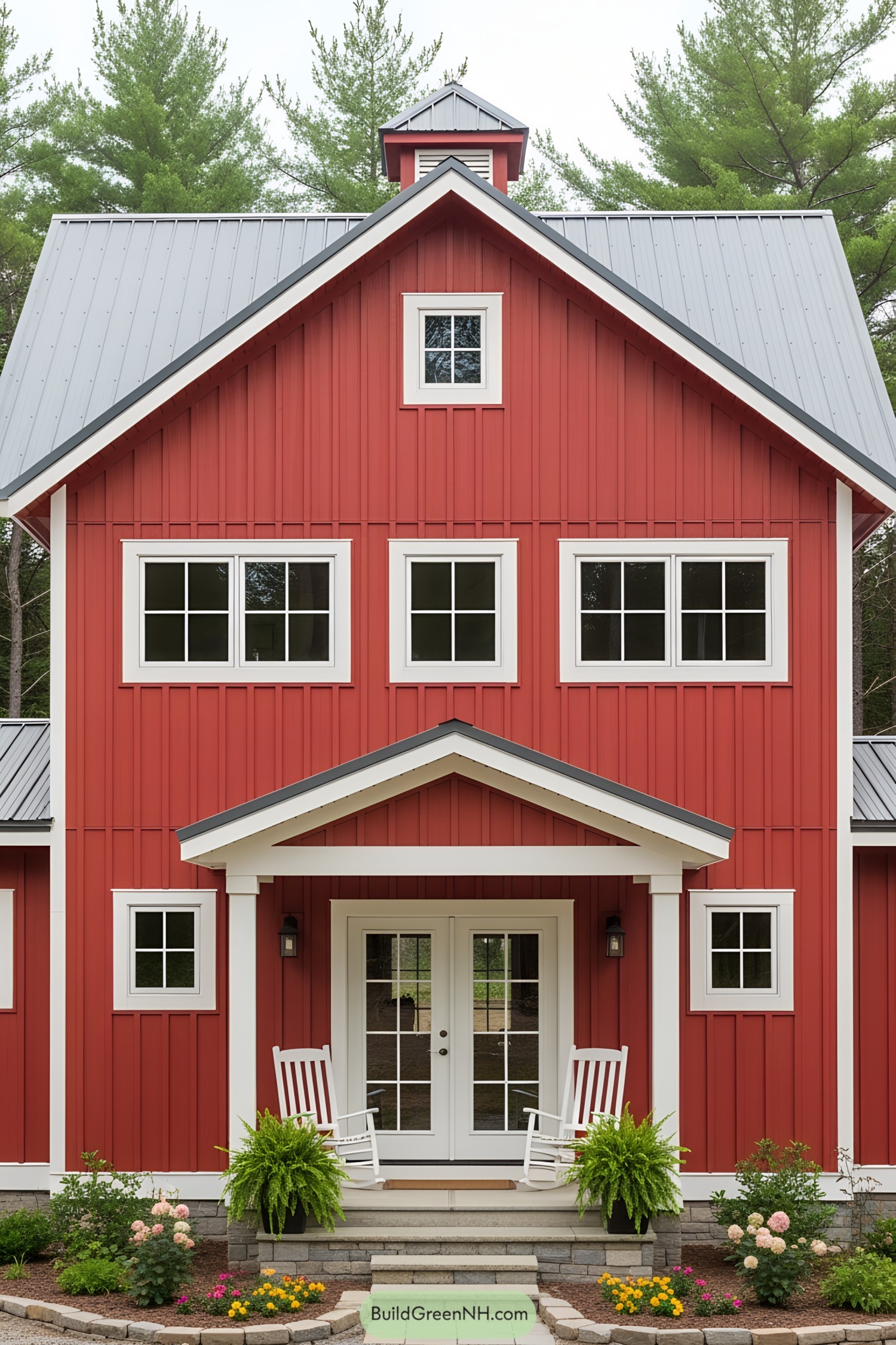 A vibrant red barn house with white-framed windows and a porch