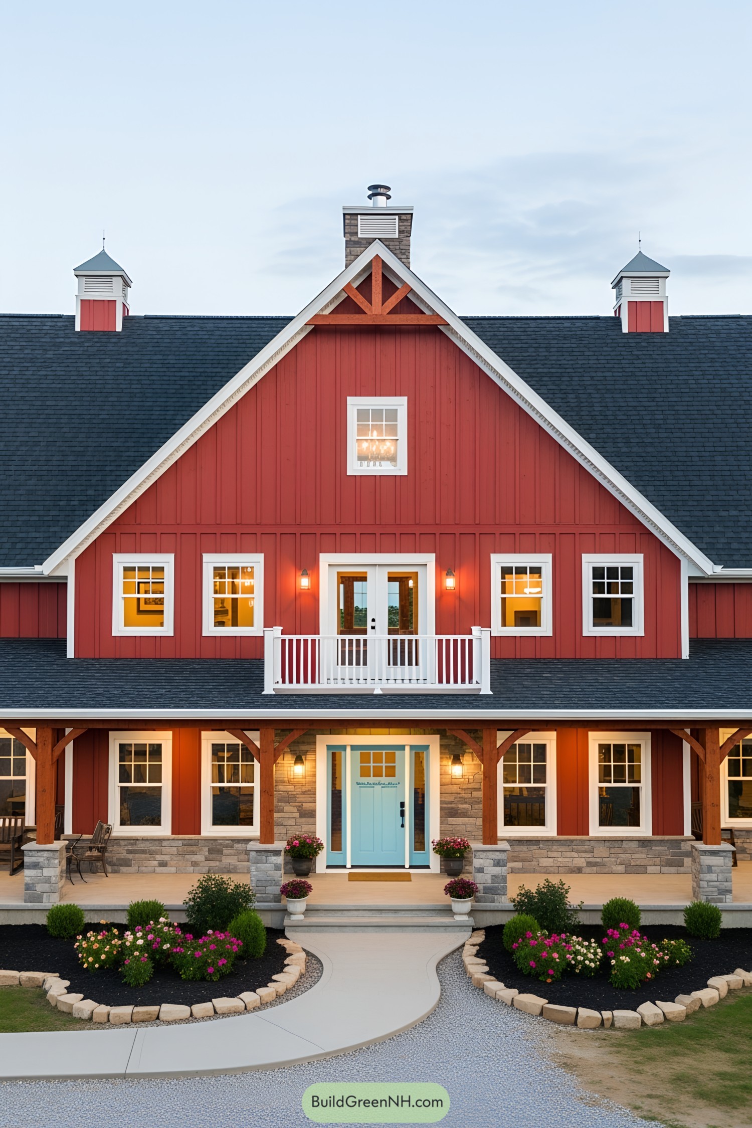 Red barn house with blue door, lit windows, and garden