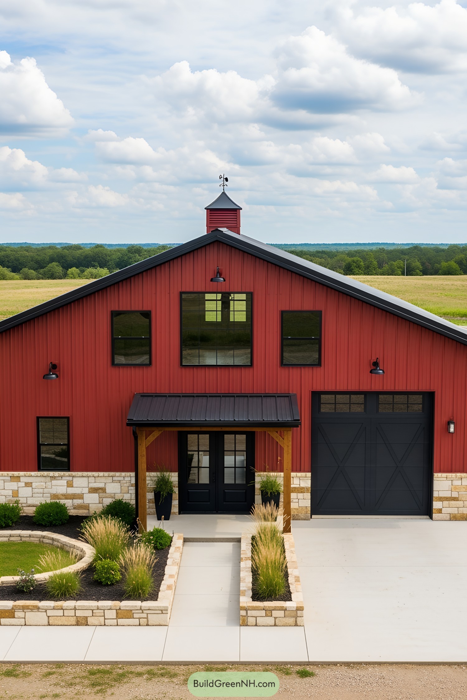 Red barndominium with stone accents, surrounded by greenery