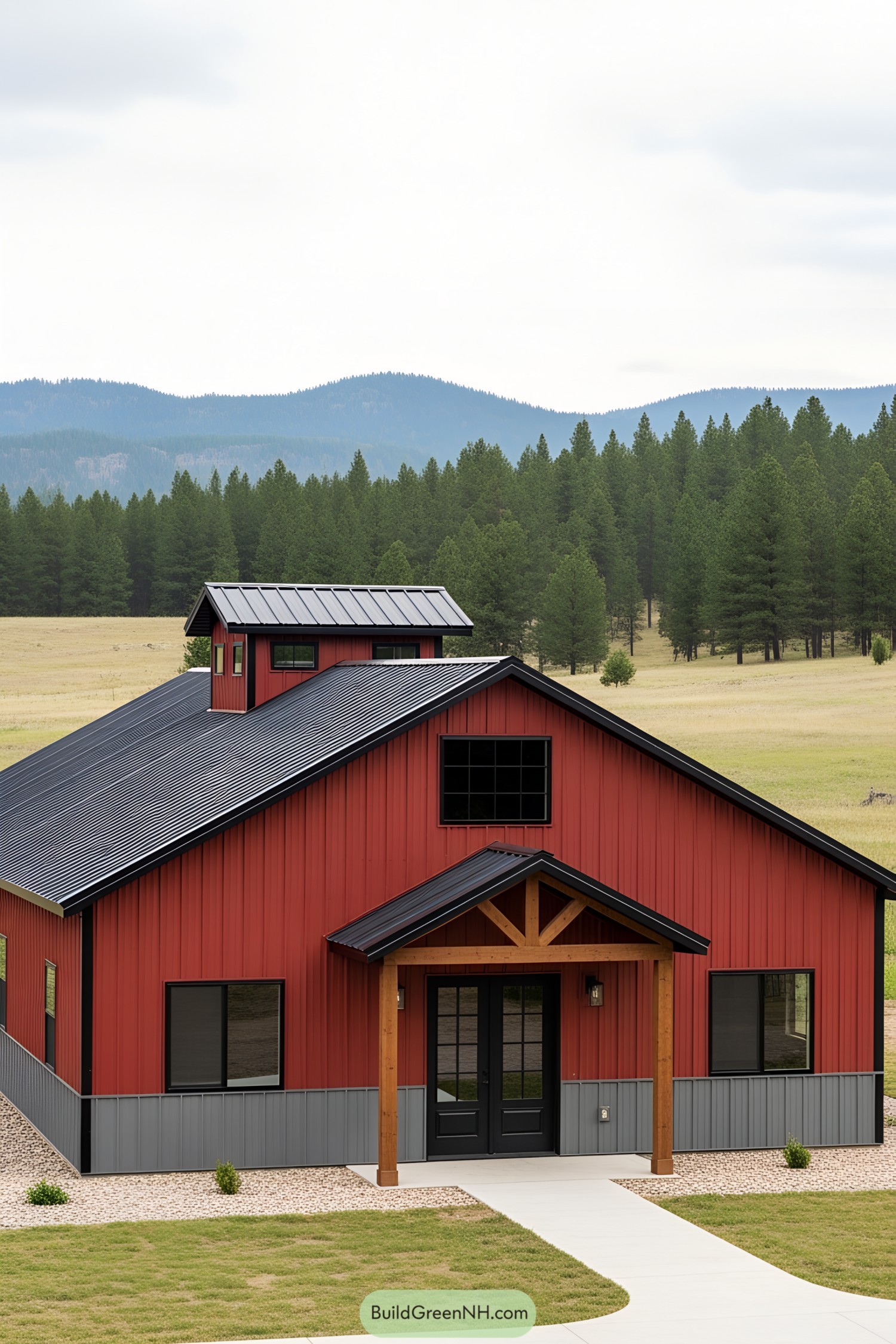 Red barndominium with dark roof and scenic backdrop