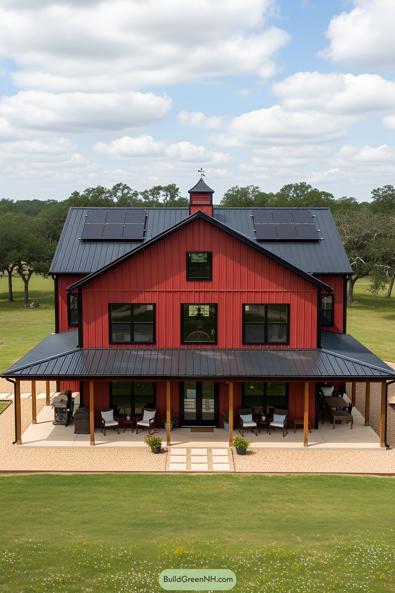 A red barndominium with solar panels and a spacious porch