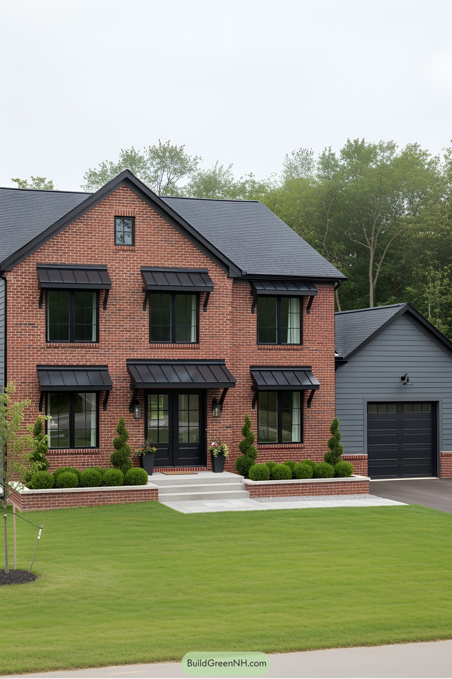 Red brick farmhouse with black trim and lush lawn