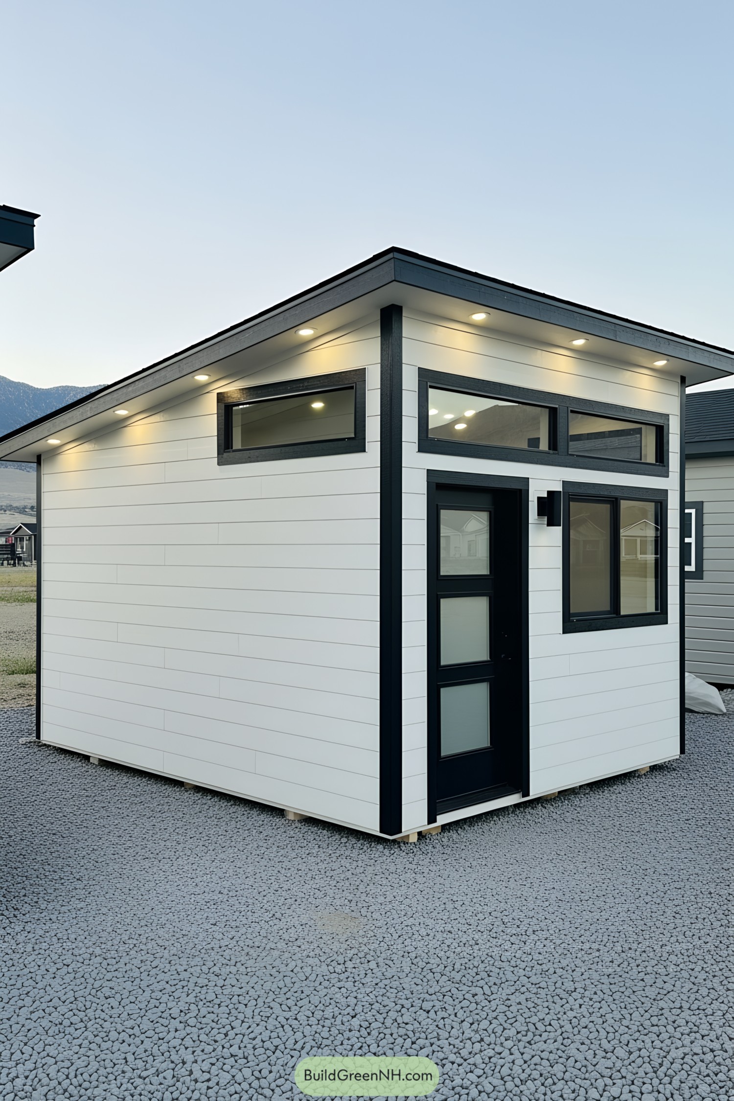 Sleek white shed with black trim and modern lighting