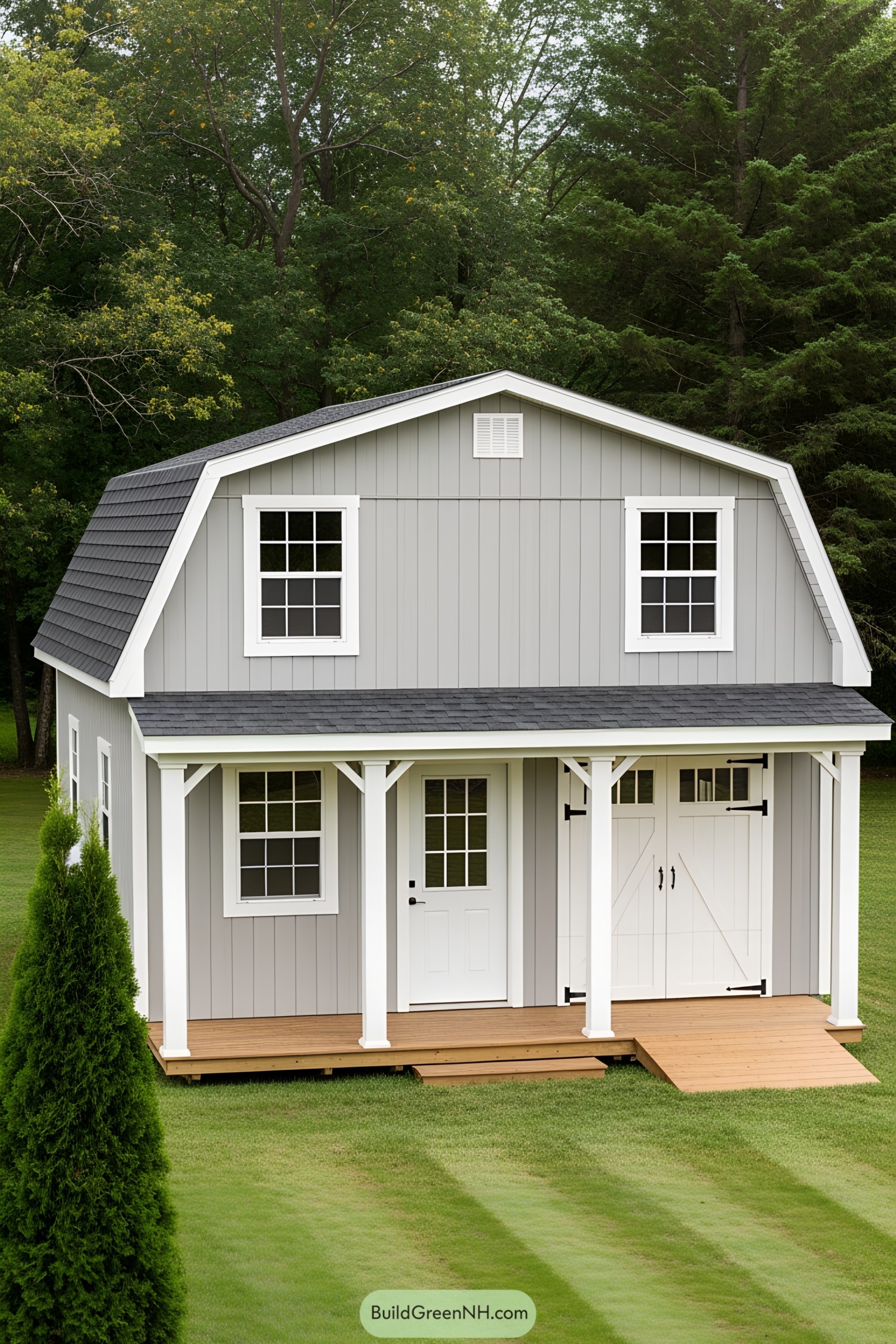 Gray barn-style shed with porch set in a grassy area