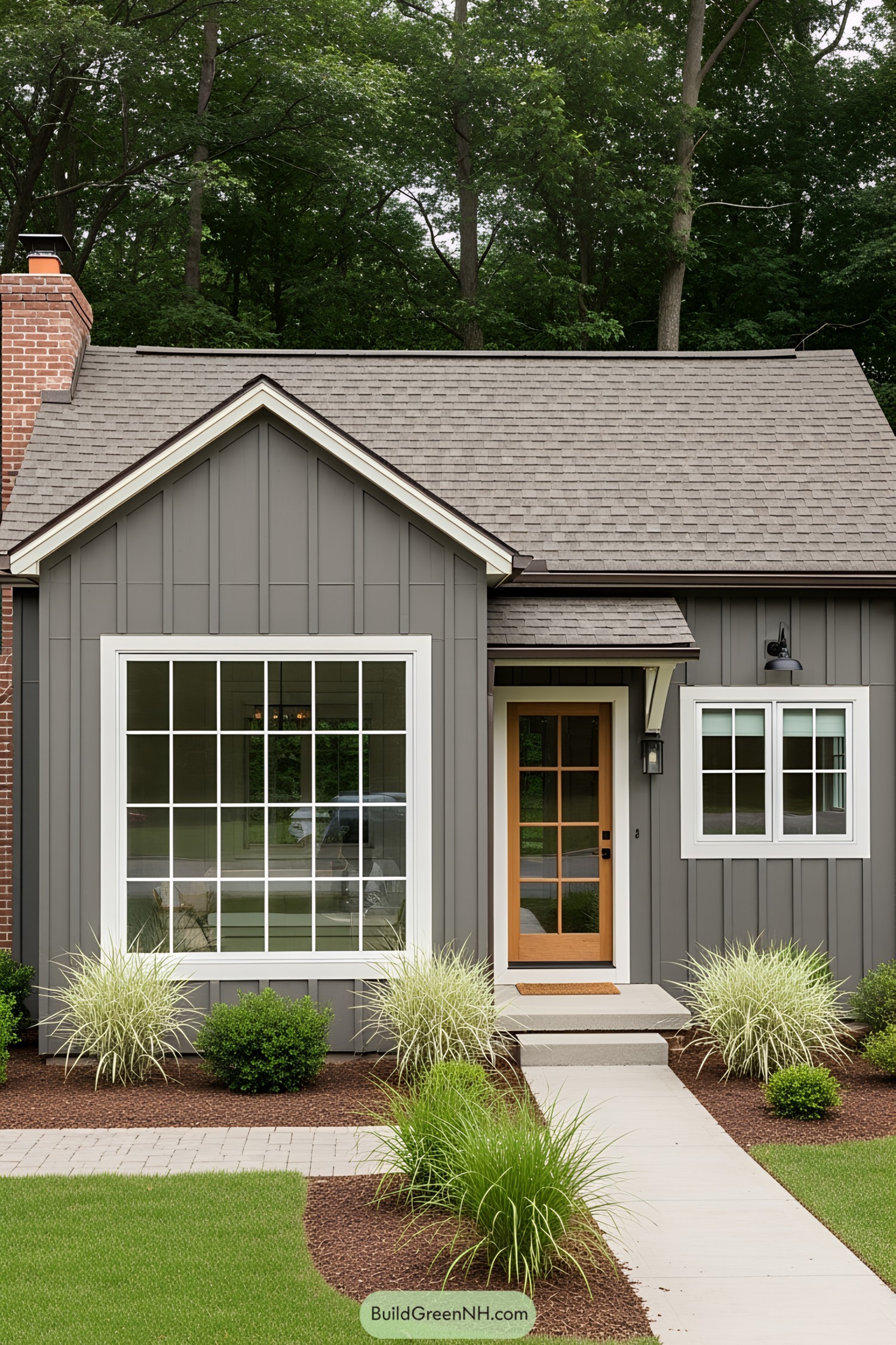 Gray cottage with brick chimney and lush surroundings