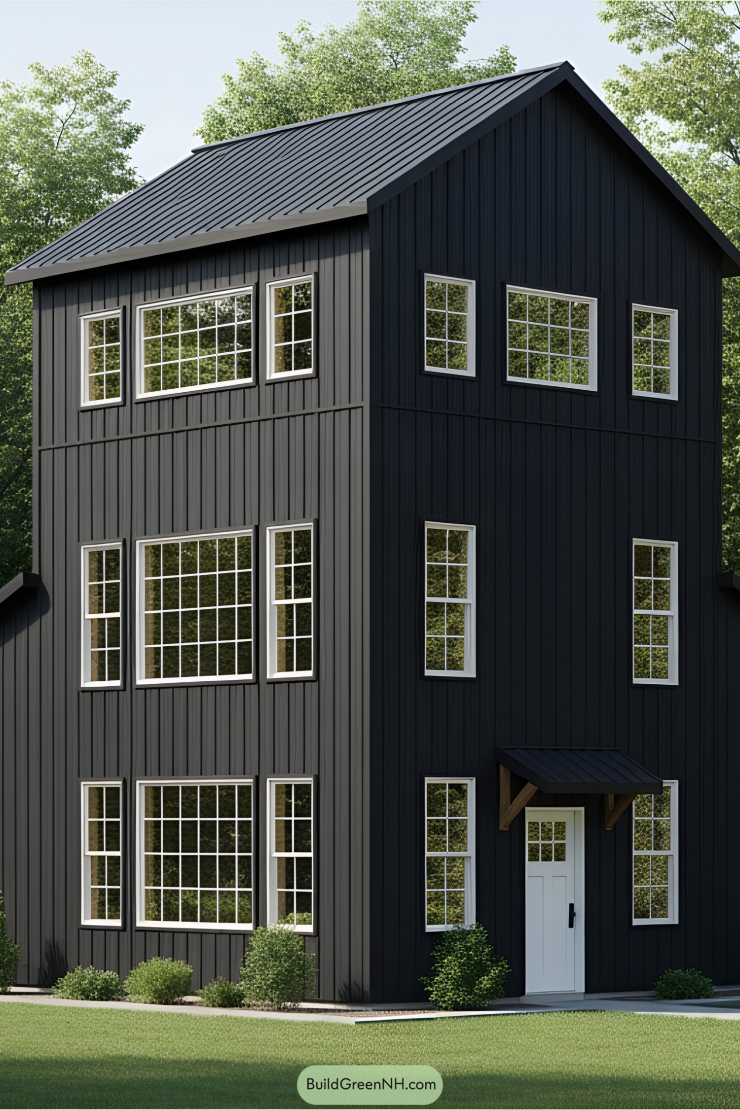 Tall black barndominium with many windows in a green setting