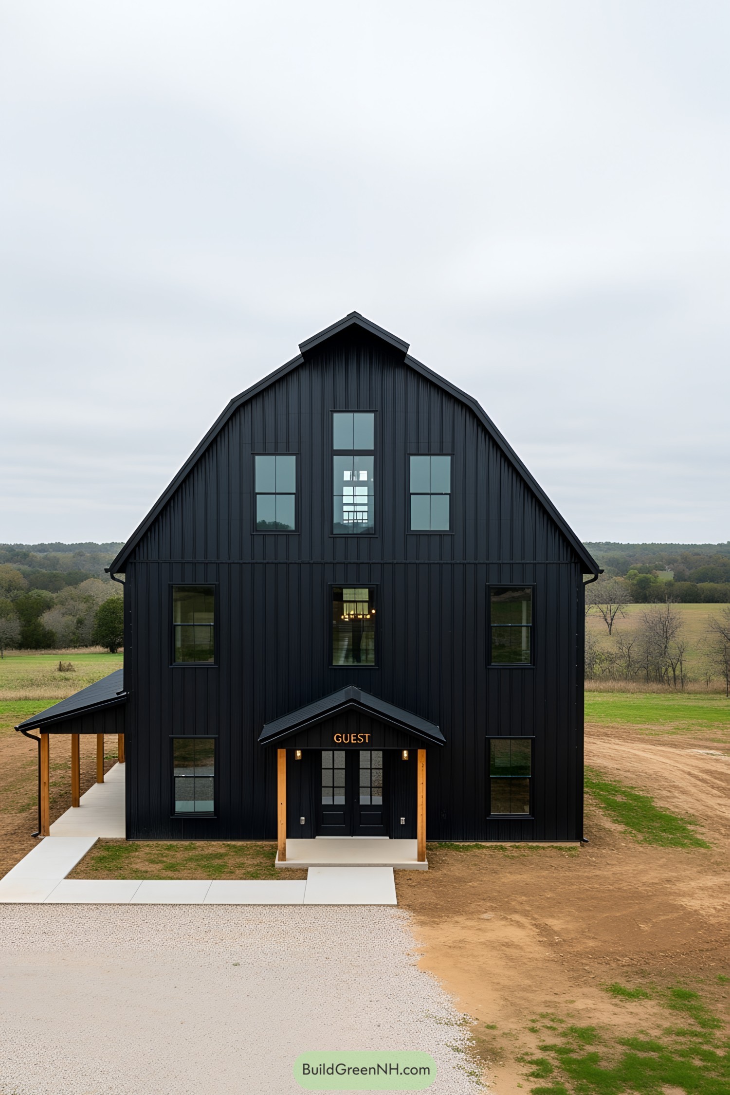 Tall black barndominium with expansive windows in a rural setting