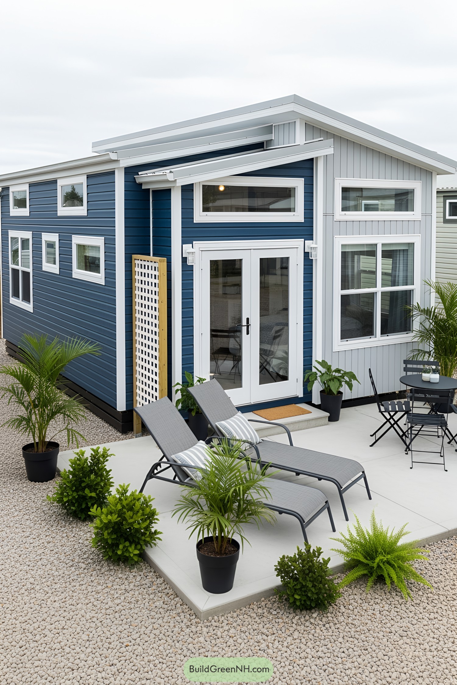 Tiny house with blue siding and a cozy patio