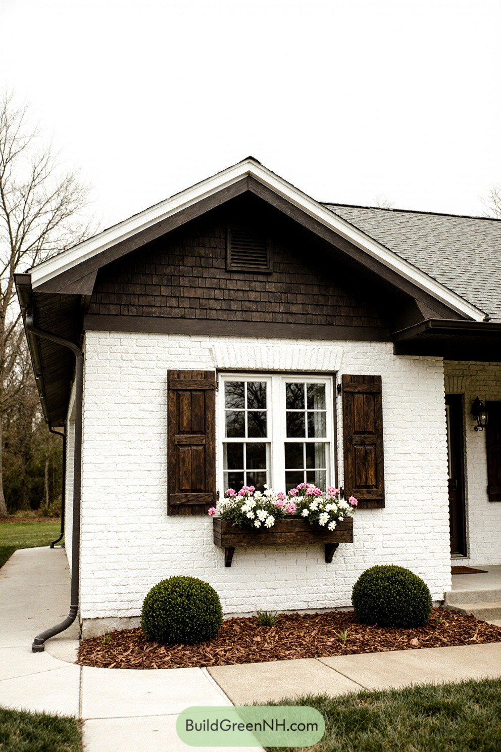 White brick house with wooden shutters and flower box