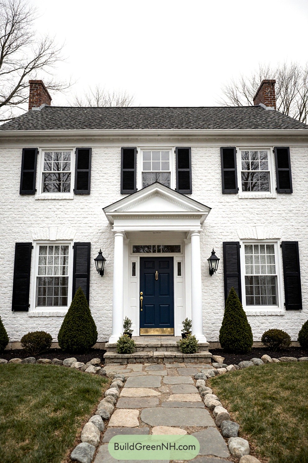Front of a white brick house with black shutters and a blue door