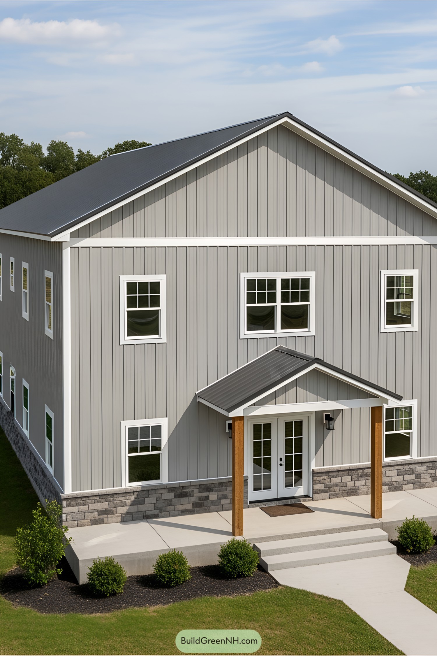 Gray barndominium with front porch and stone foundation