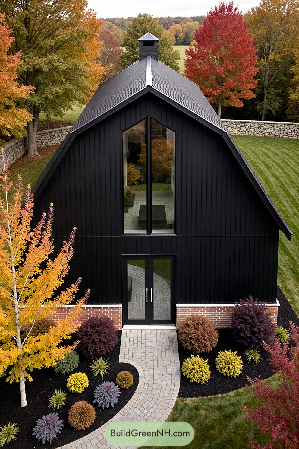 Black barndominium surrounded by vibrant fall foliage