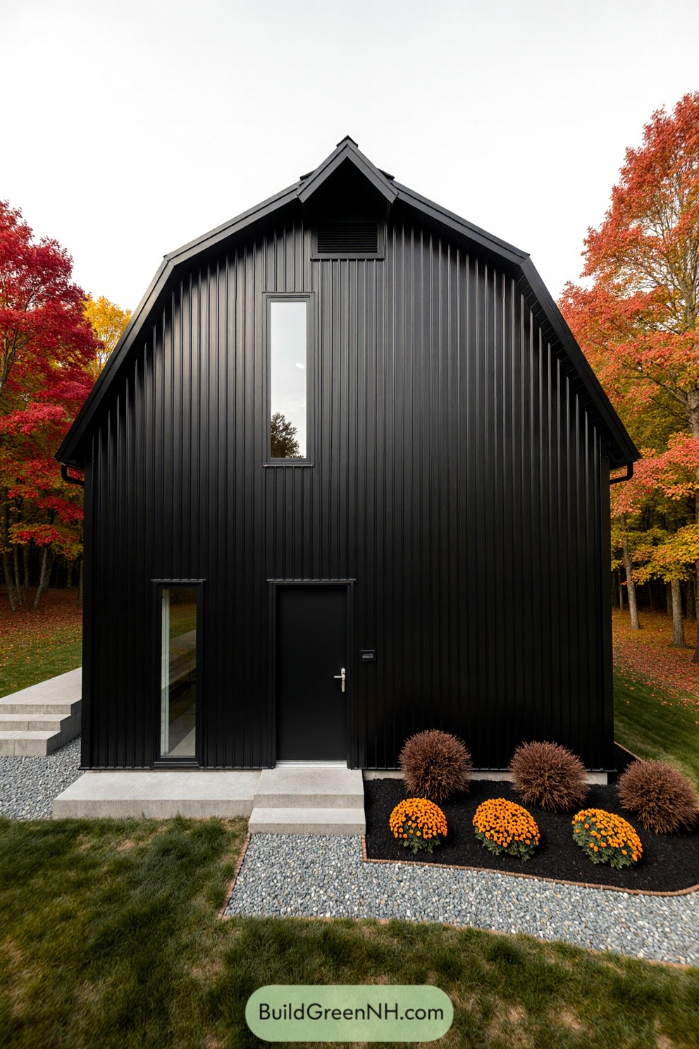 Modern black barndominium surrounded by vibrant autumn trees