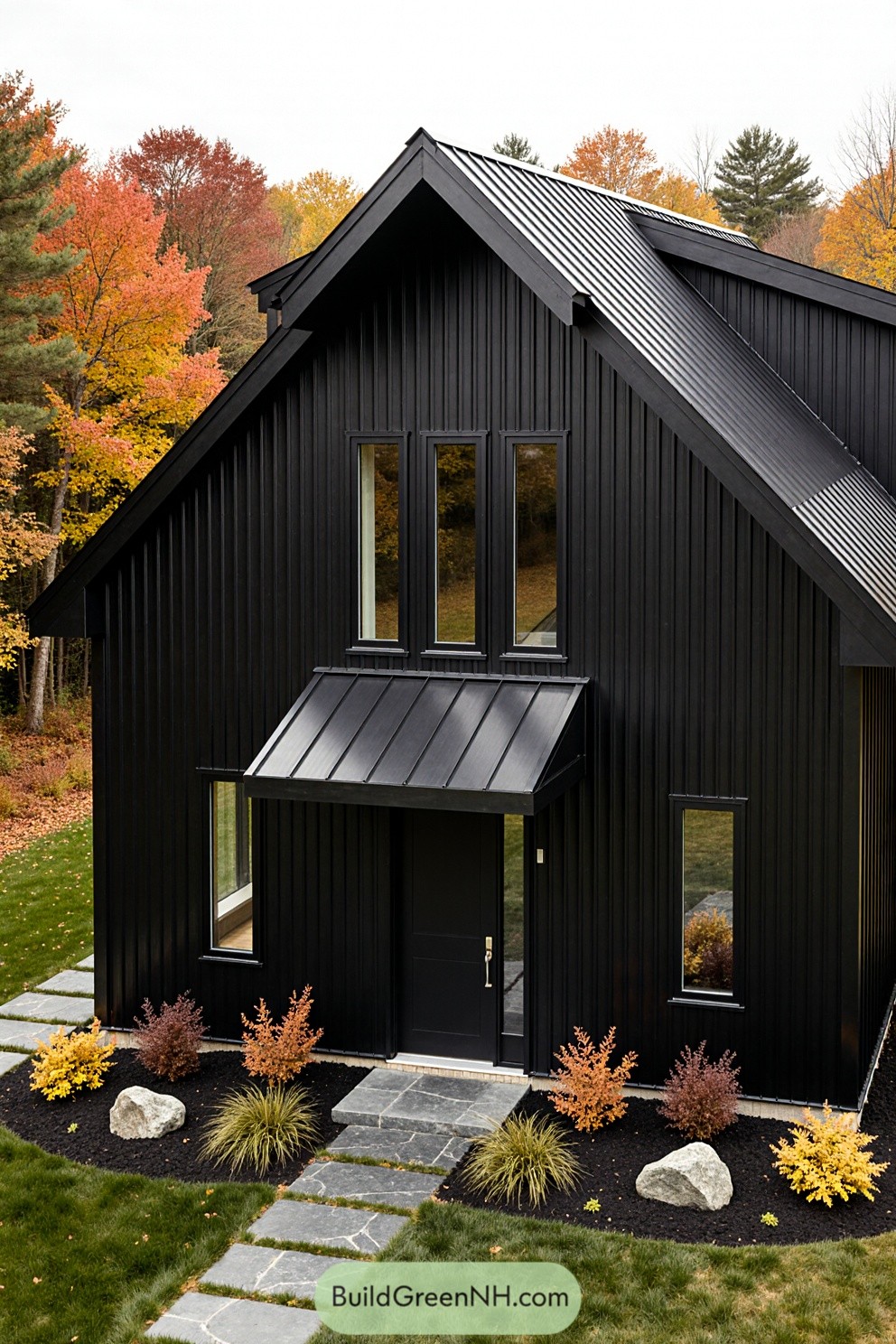 Black barndominium with fall foliage