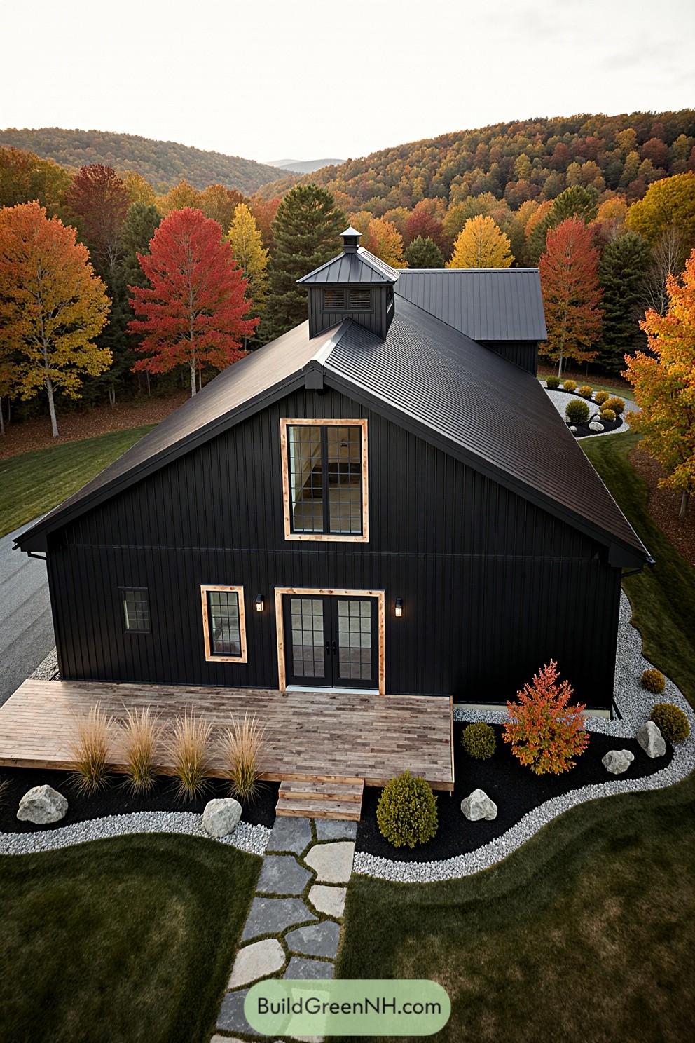Black barndominium surrounded by colorful autumn foliage