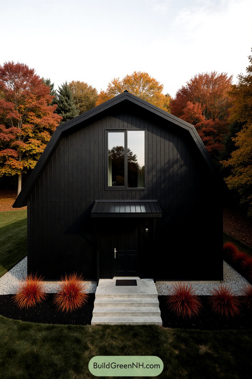 A black barndominium framed by vibrant fall trees