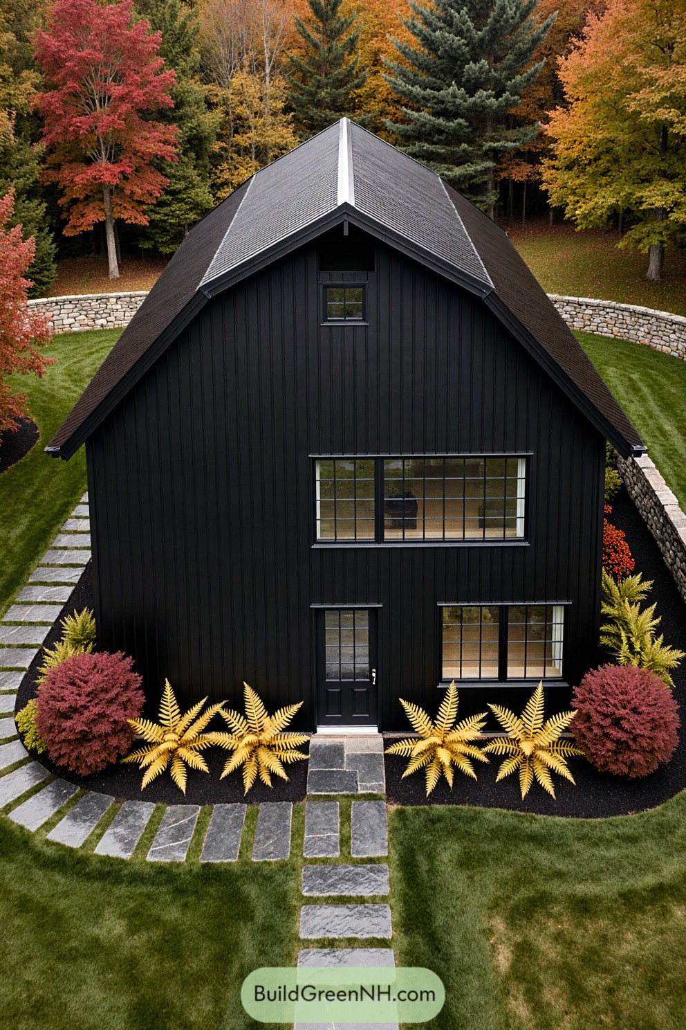Black barndominium surrounded by colorful autumn trees
