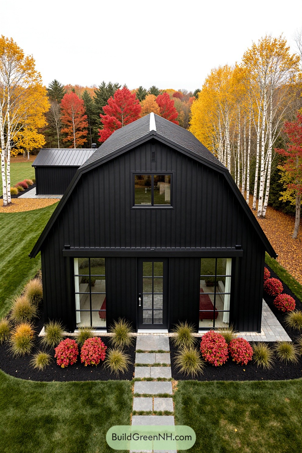 Black barndominium surrounded by vibrant fall foliage
