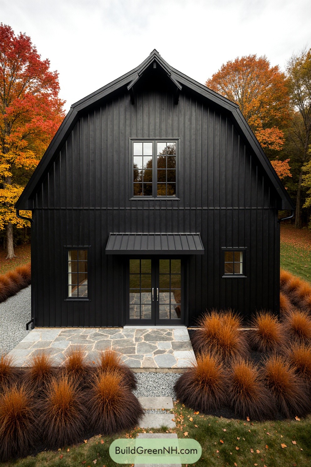 Black barndominium surrounded by vibrant autumn foliage