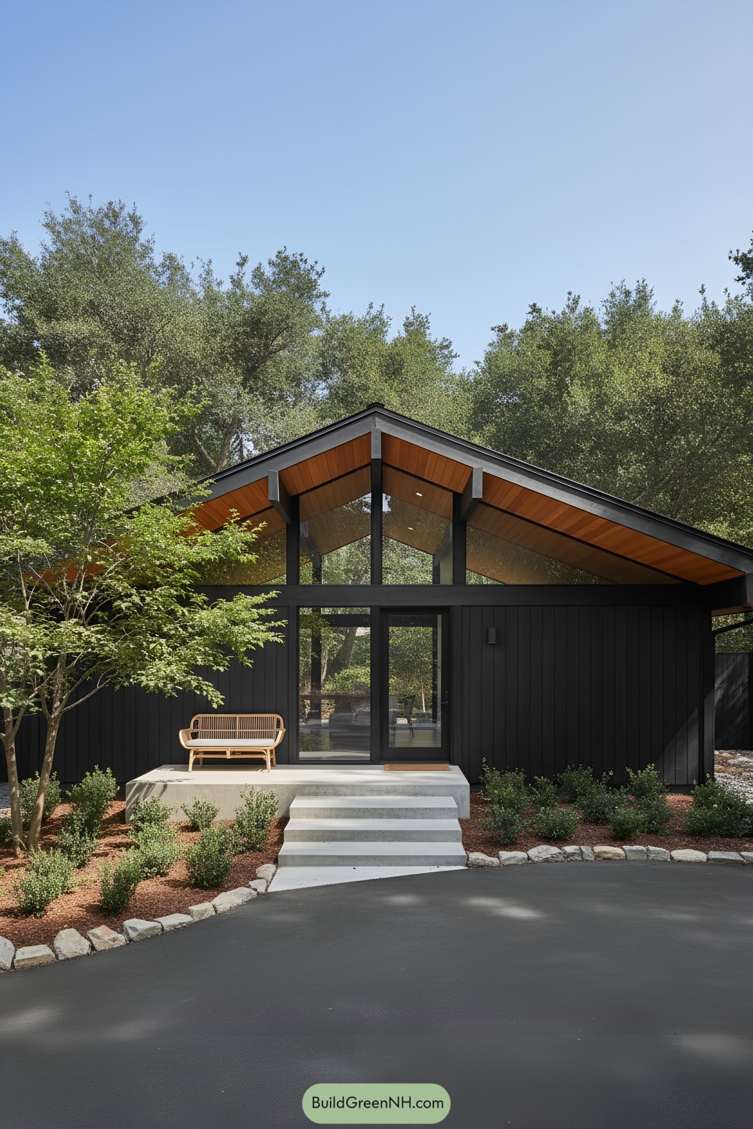 Contemporary black A-frame house surrounded by lush trees