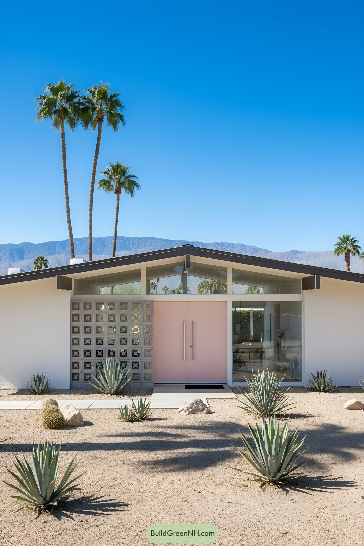 A mid-century modern house with a pink door and desert landscaping