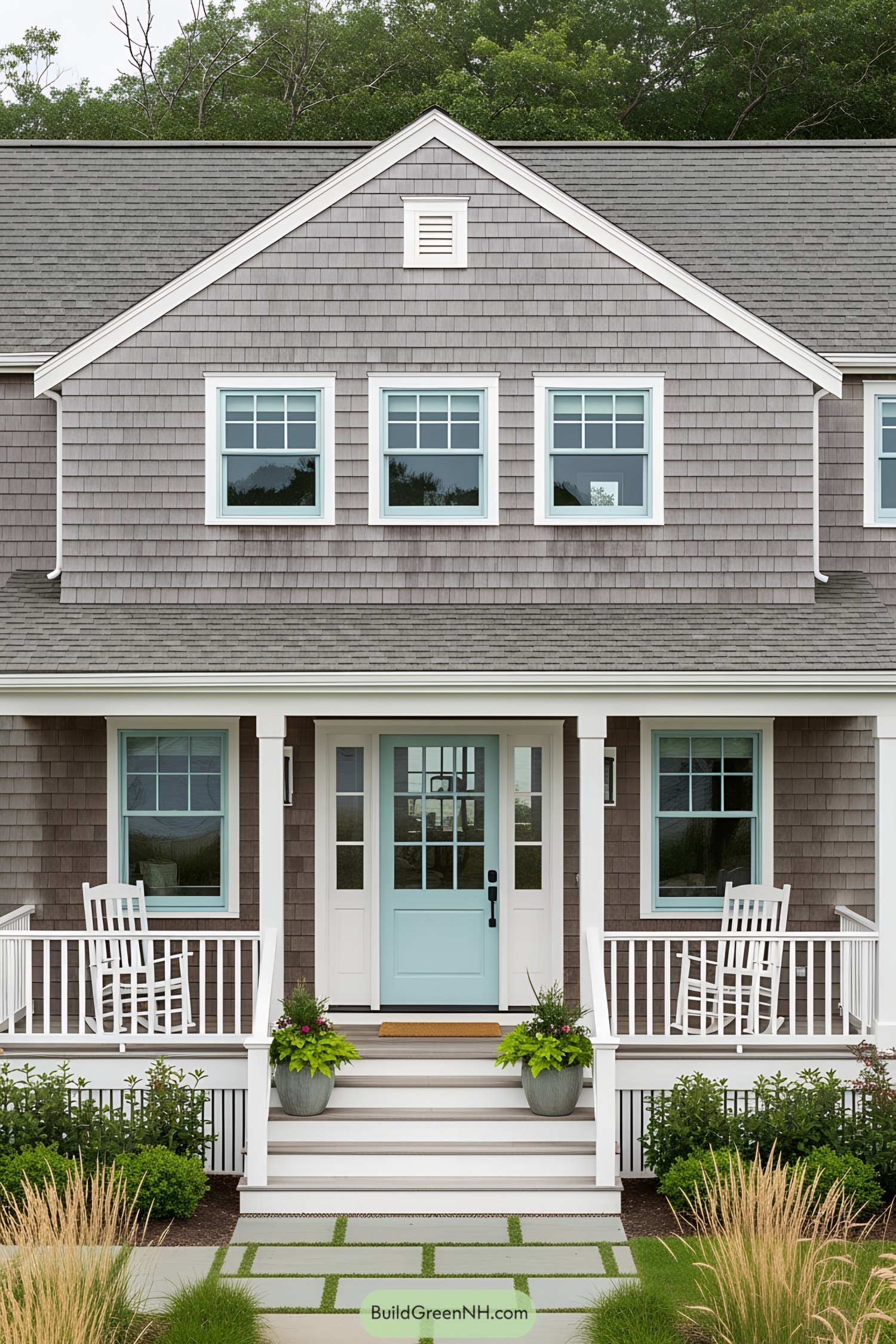 Two-story gray cottage with rocking chairs on the porch
