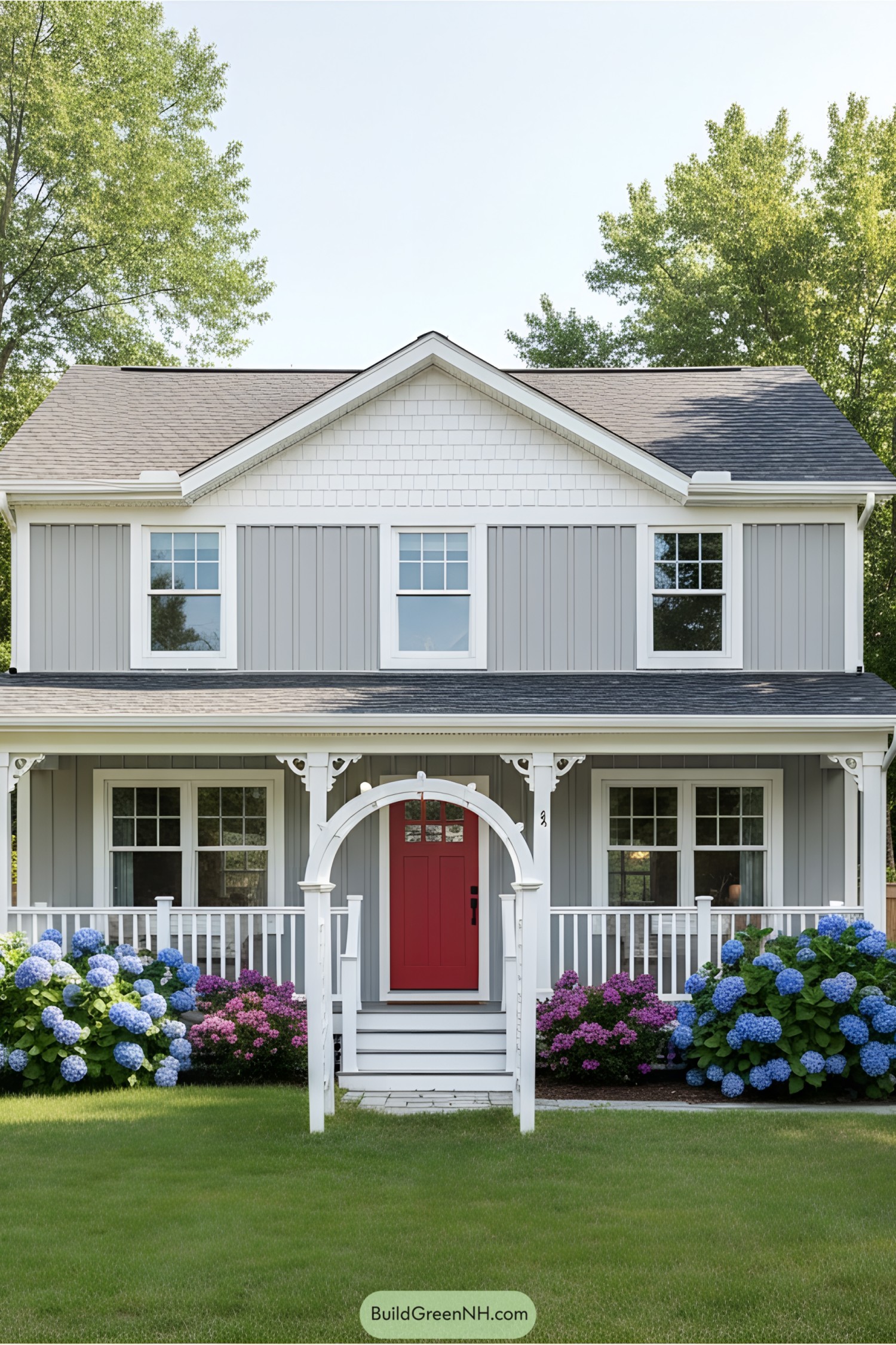 Gray cottage with a red door and blooming hydrangeas