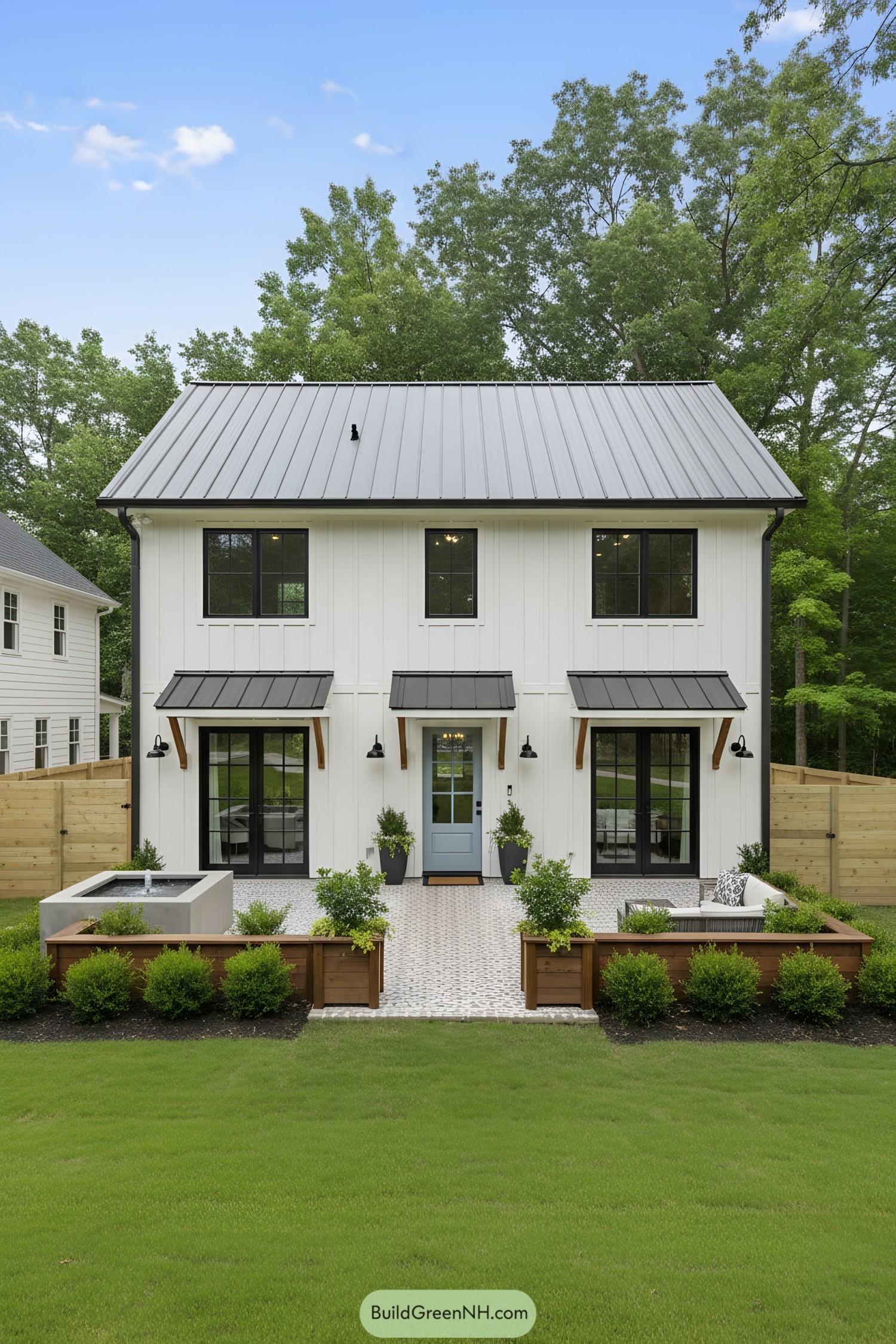 White two-story house with a sleek metal roof and spacious patio