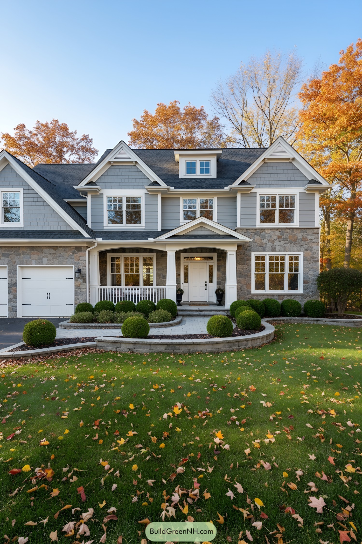 A classic suburban home surrounded by autumn trees and a manicured lawn