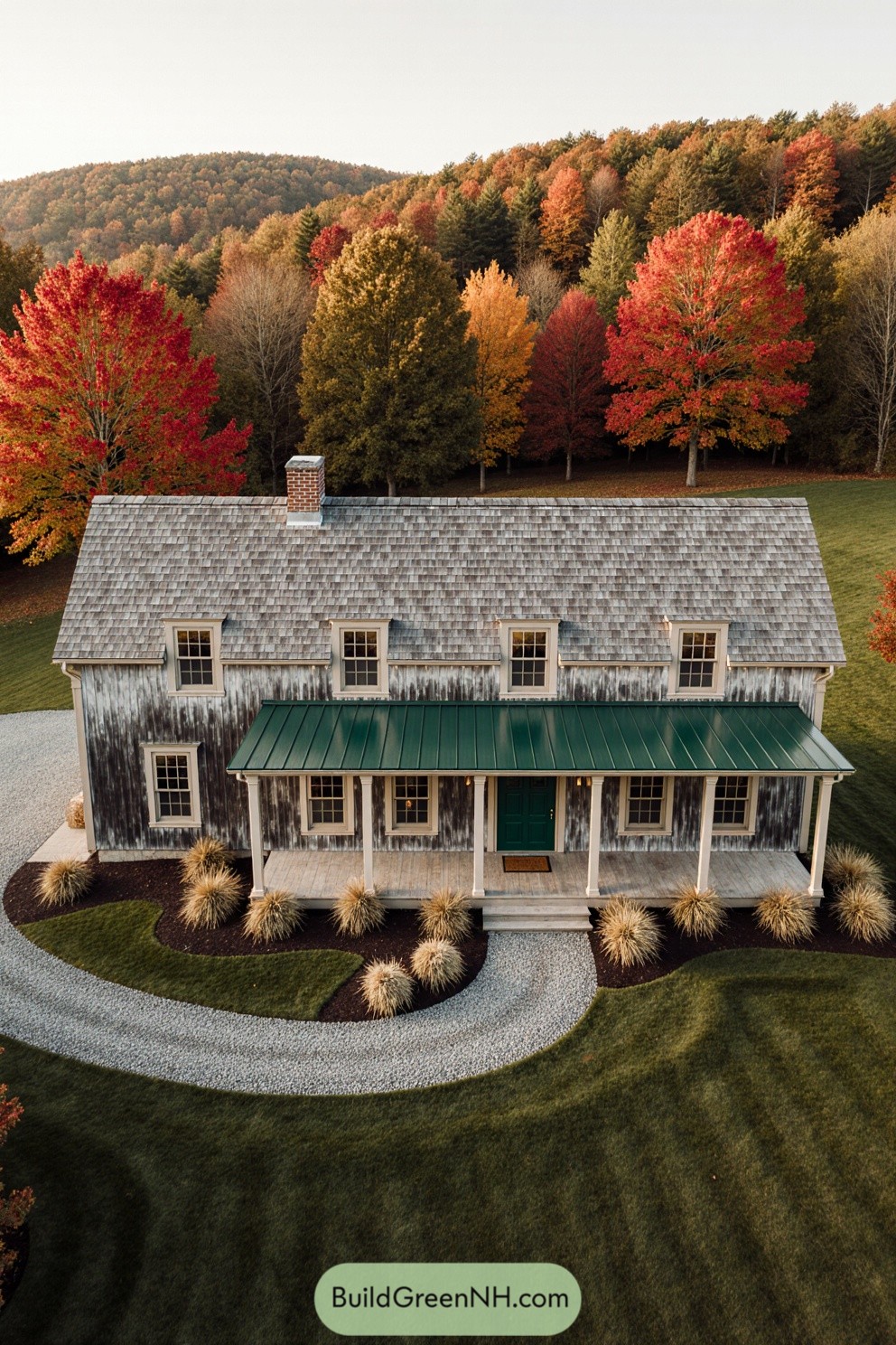Aerial view of a rustic farmhouse surrounded by colorful autumn trees