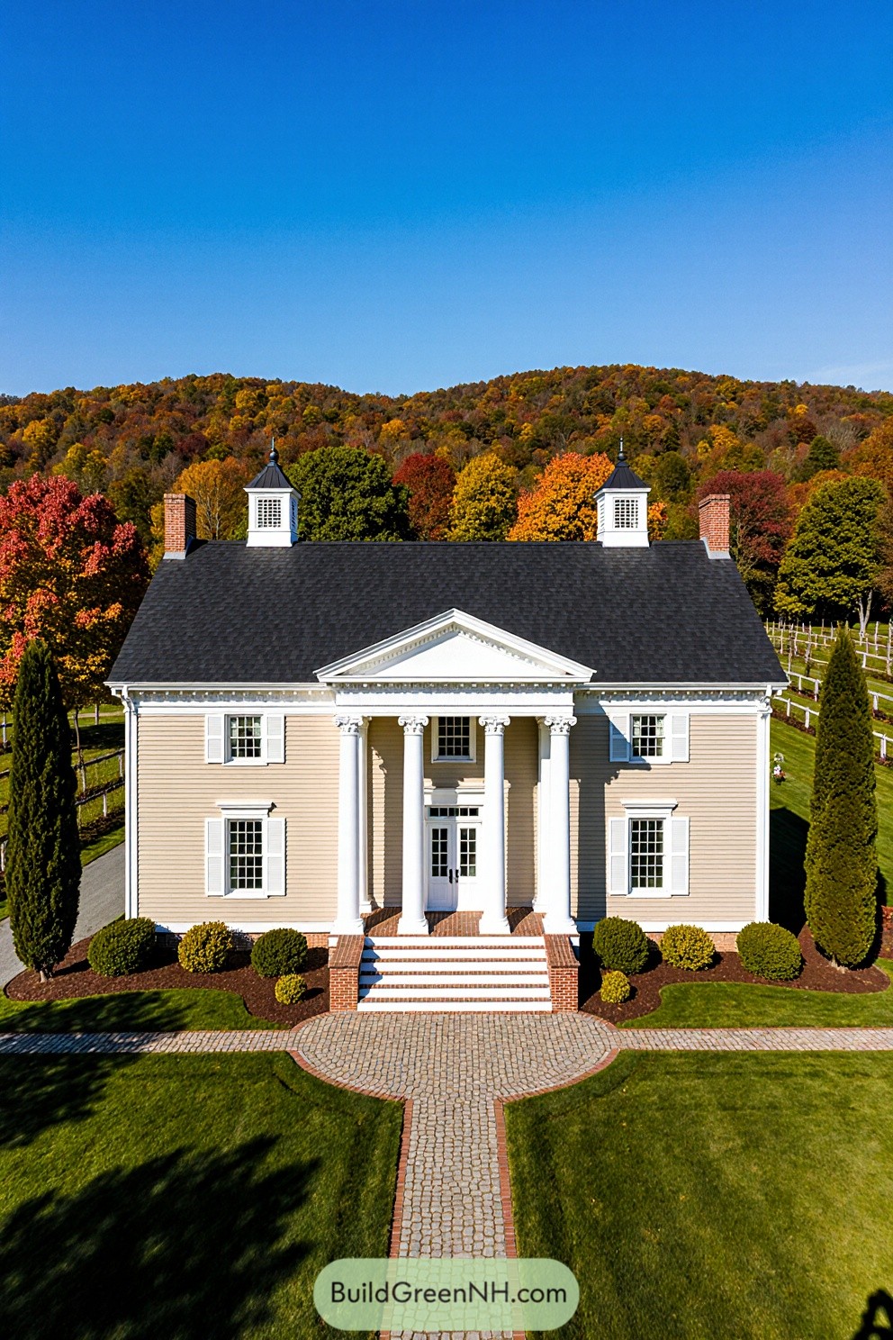 Colonial house surrounded by vibrant autumn trees