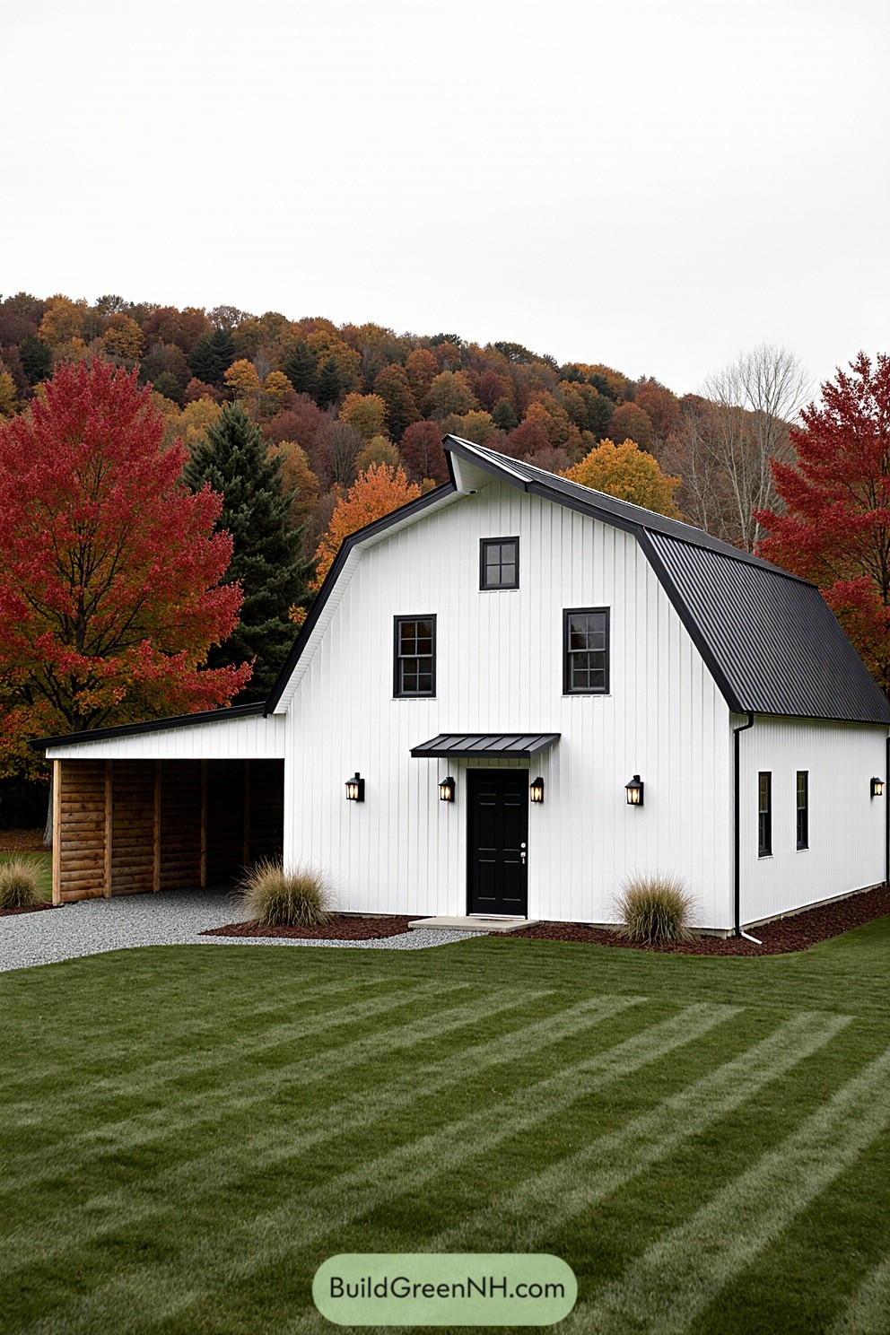 White barn with black roof surrounded by colorful autumn foliage