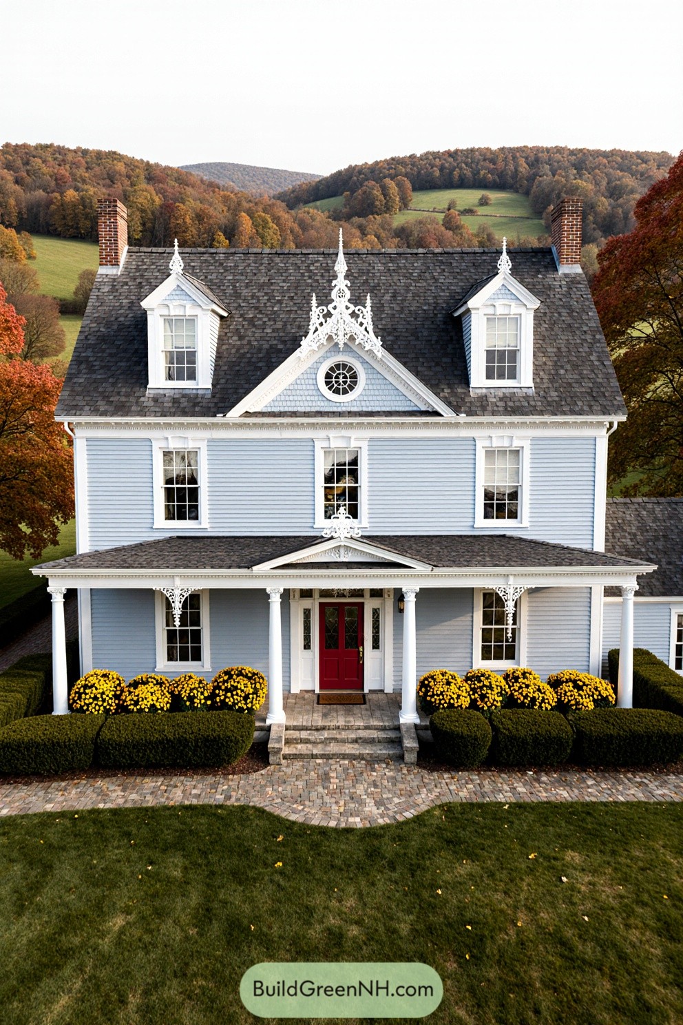 Blue farmhouse with red door and fall foliage