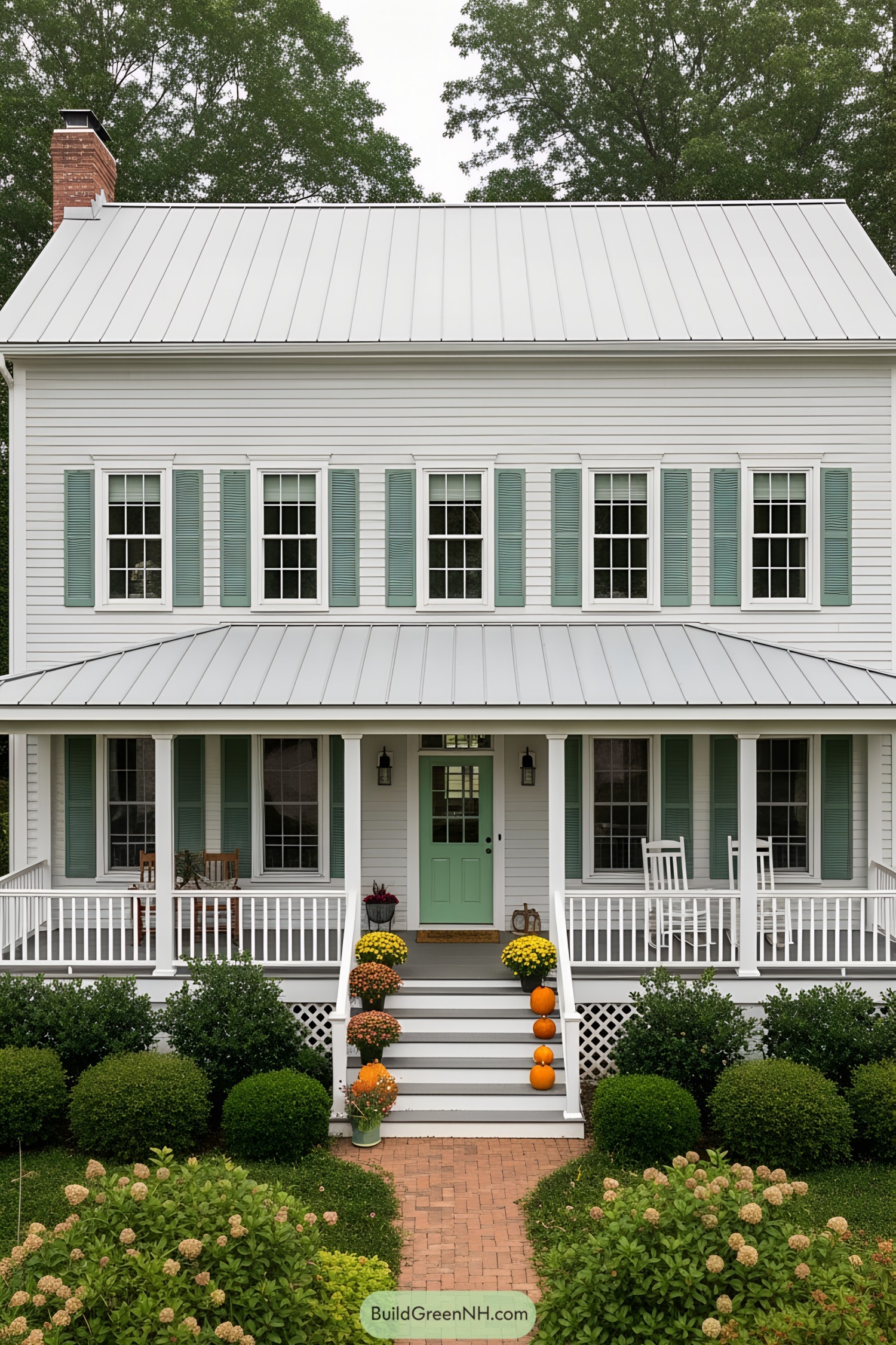 White farmhouse with aqua accents and porch steps adorned with pumpkins