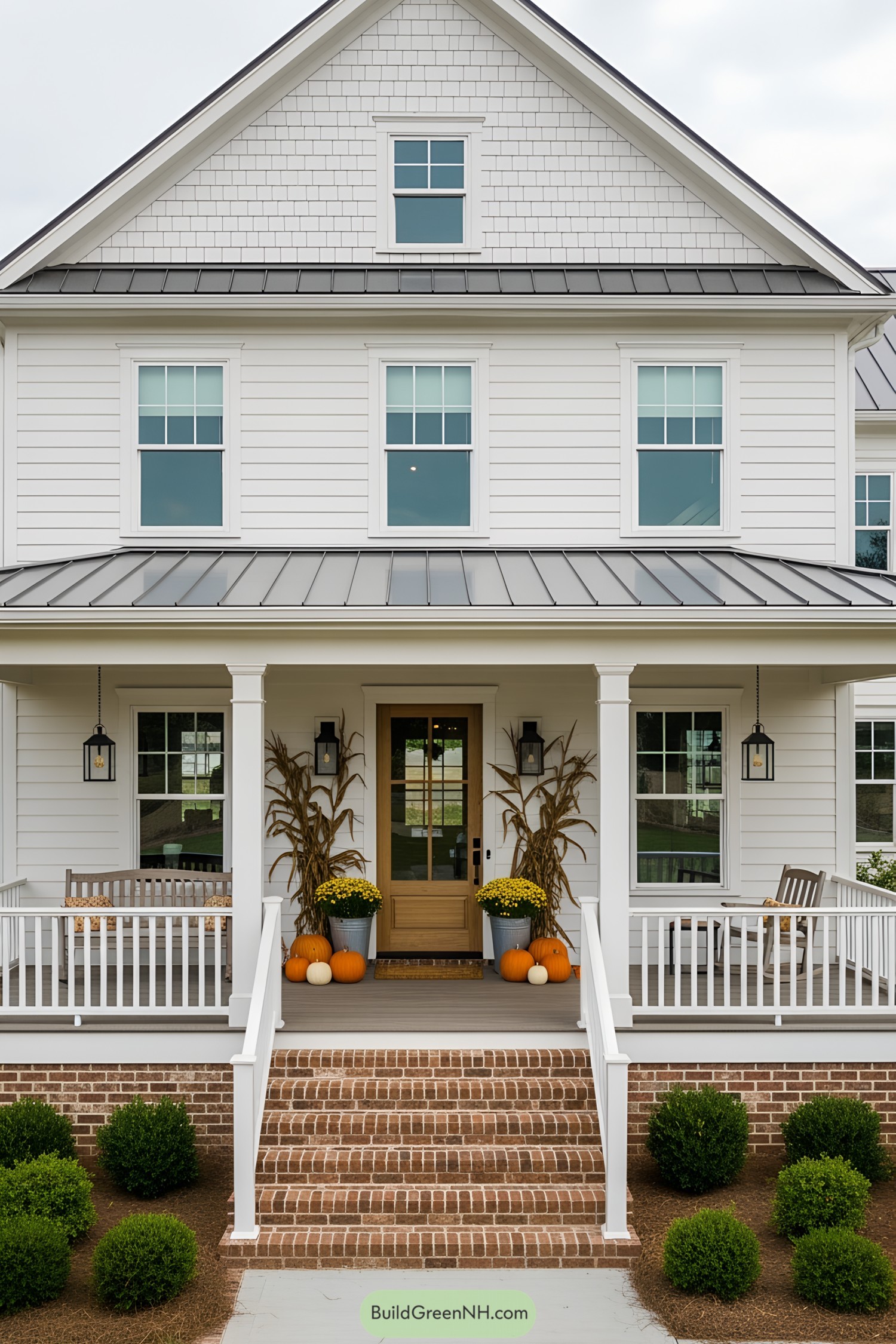White farmhouse with a porch and pumpkins