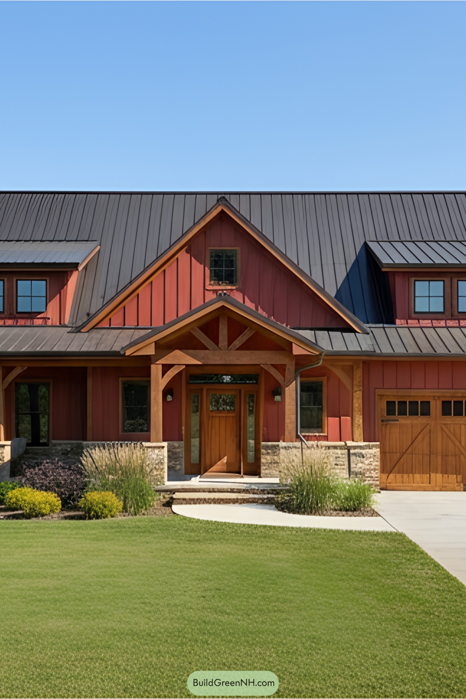 A red barndominium with a wooden porch and lush lawn