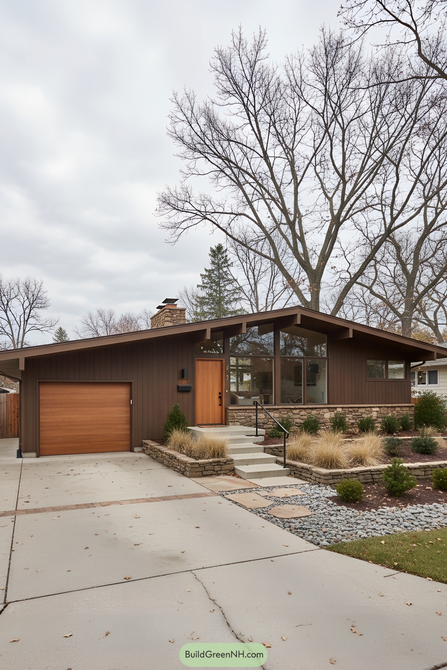 Mid-century modern house with brown facade and large windows amidst tall bare trees