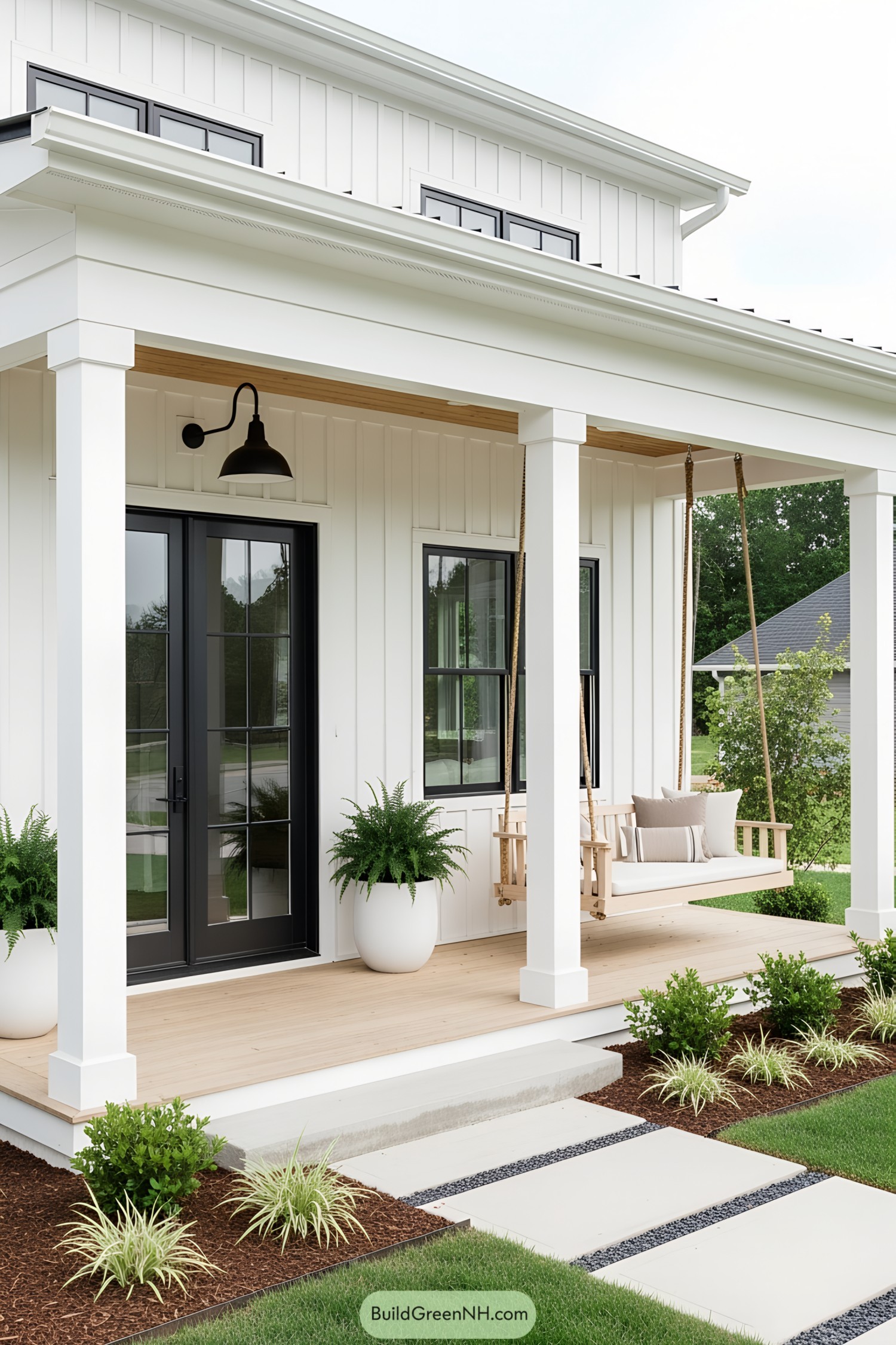 Modern porch with white columns, potted ferns, and a swing